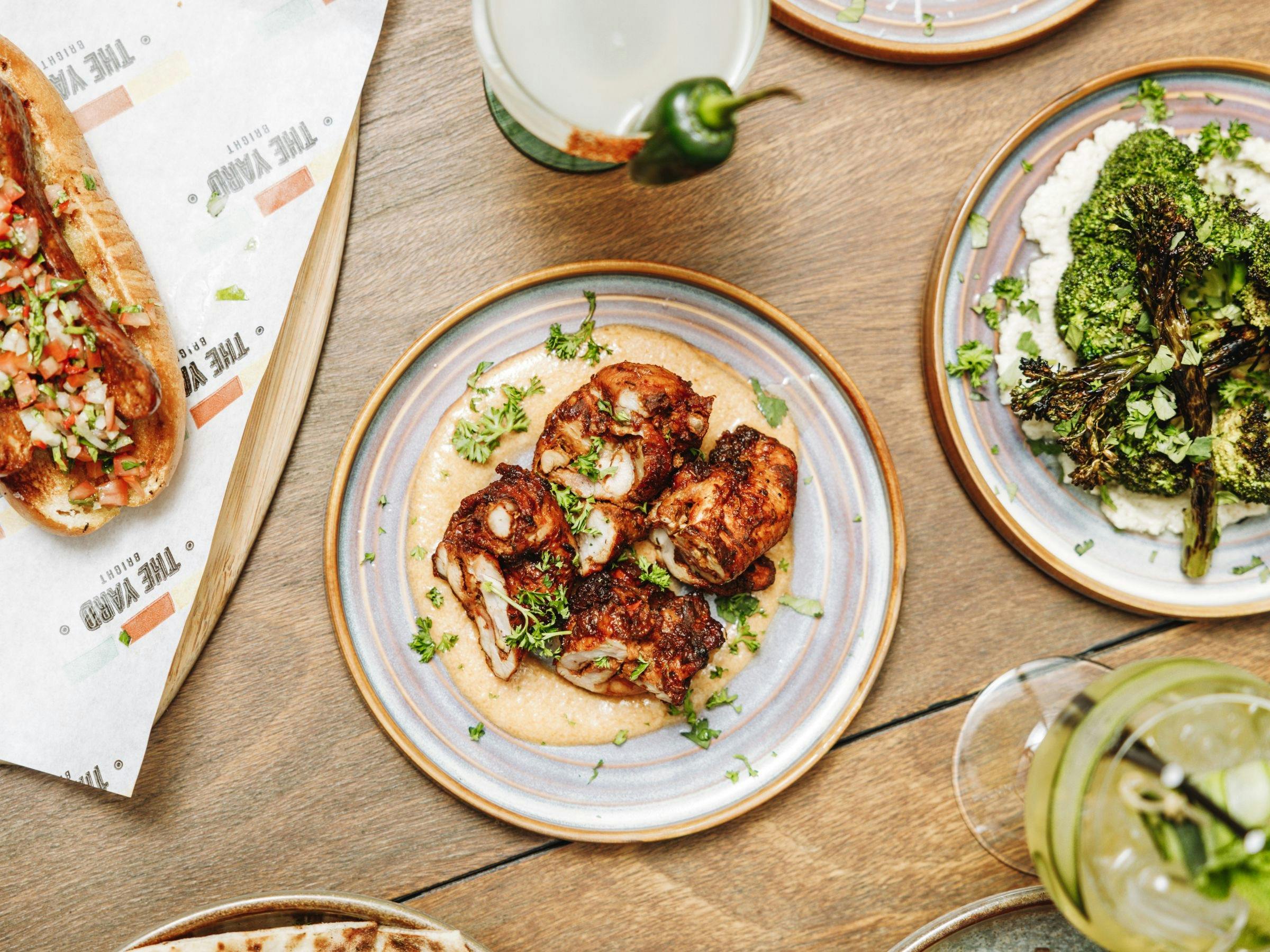 Fire grilled chicken and other dishes on the table at The Yard