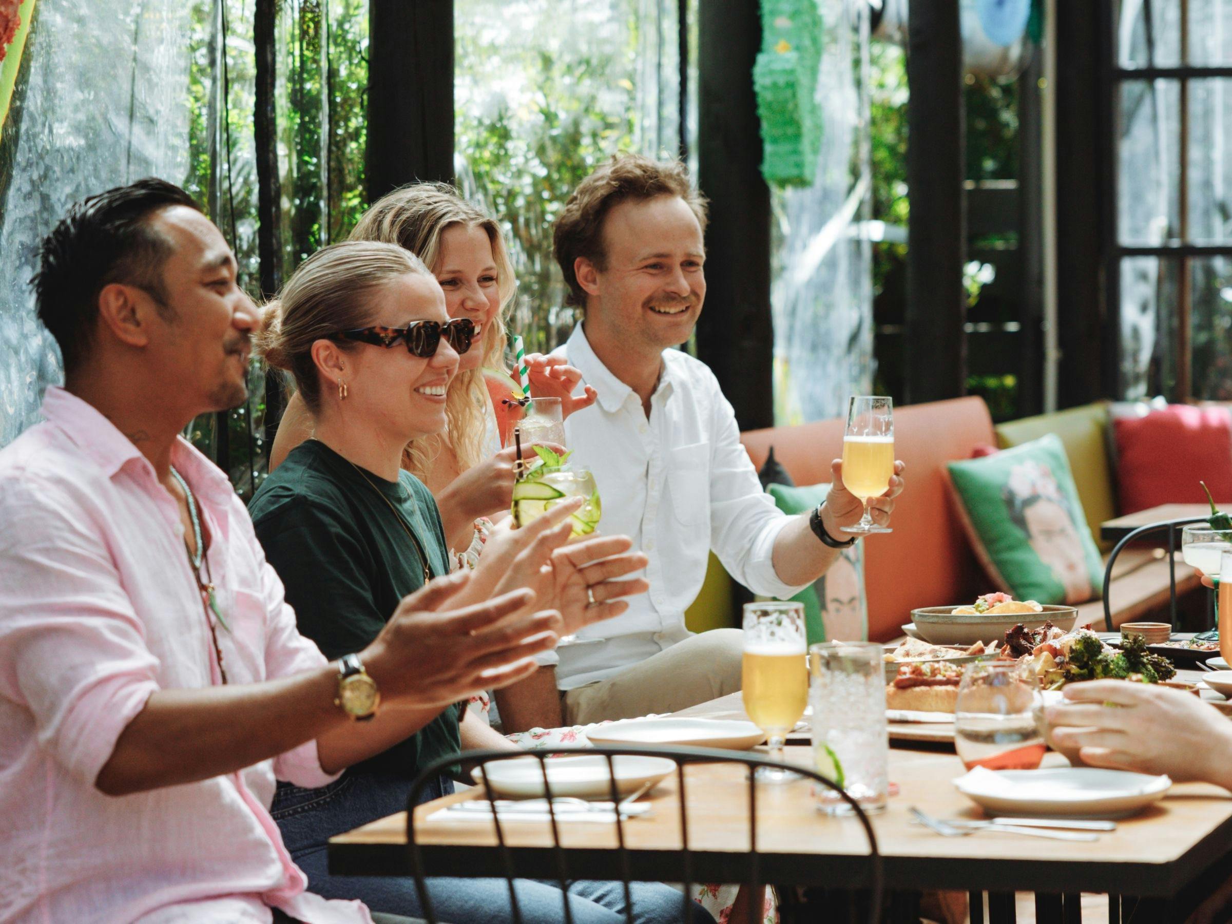 Friends enjoying a summer meal with drinks at The Yard