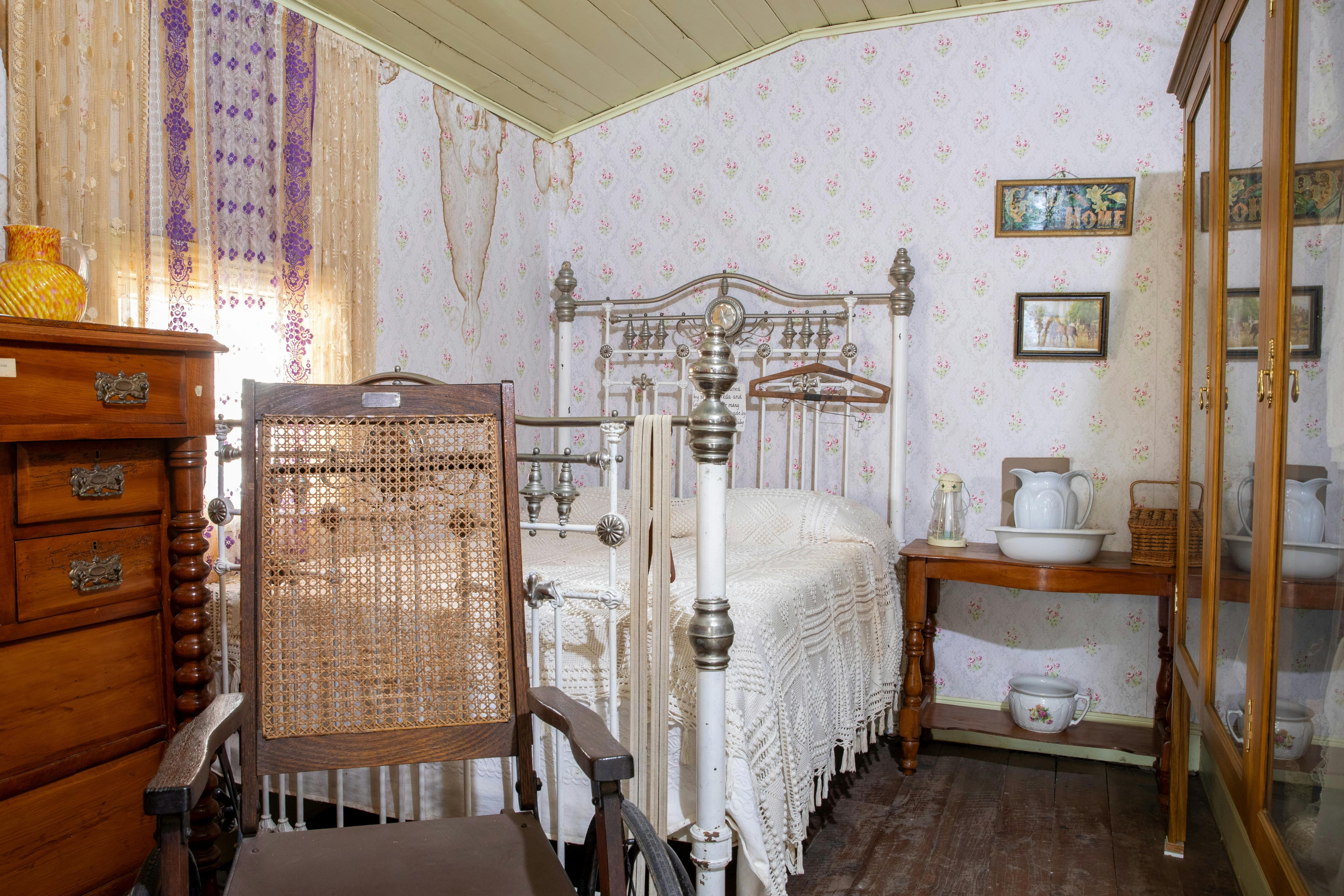 Old fashioned brass bed set up in an oldfashioned room set up in a Museum