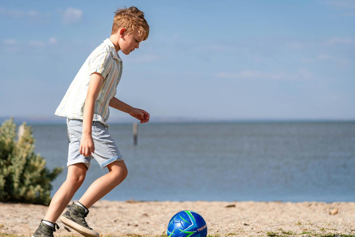 child kicking soccer ball at Werribee South Foreshore