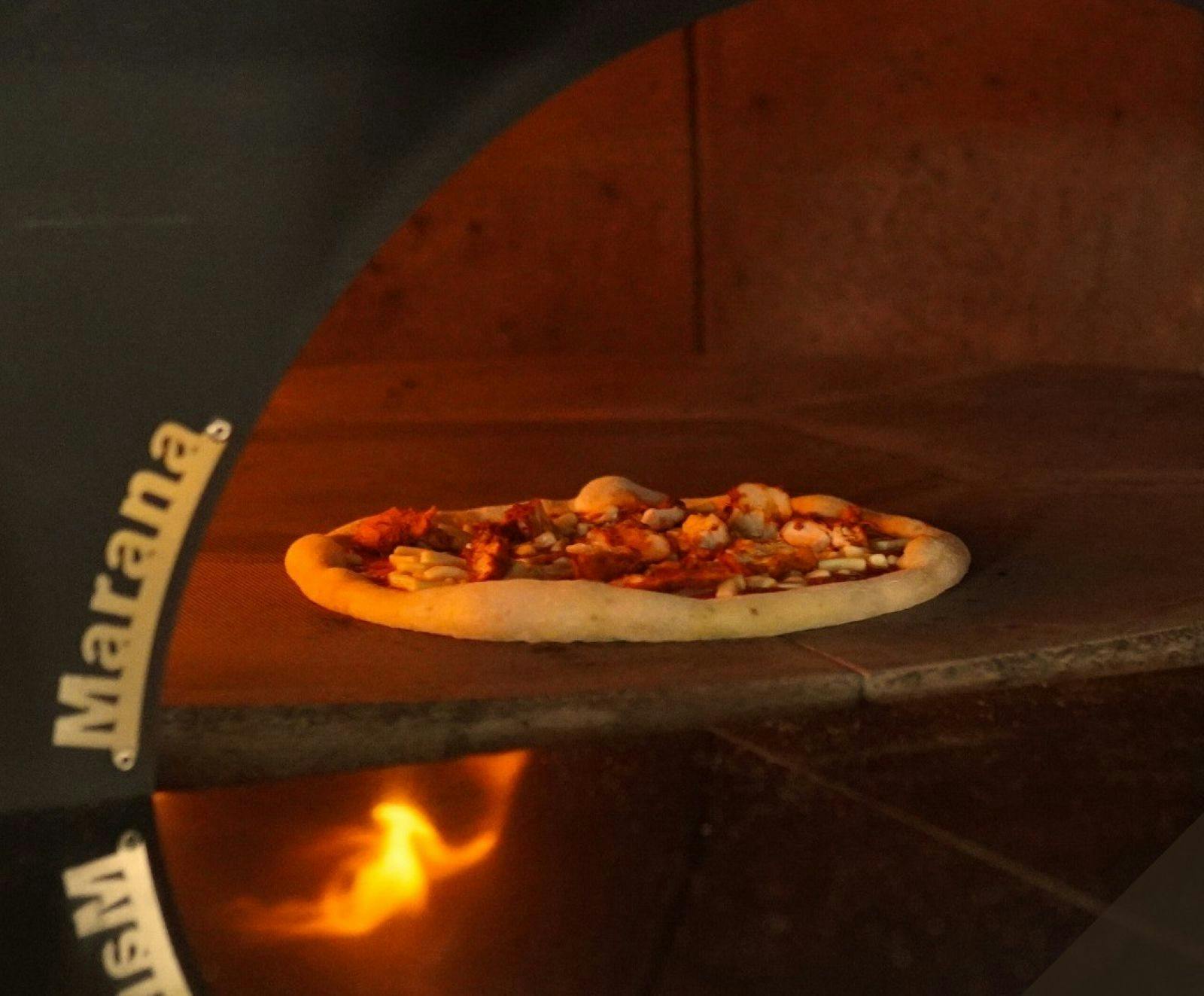 A pizza cooking in a pizza oven