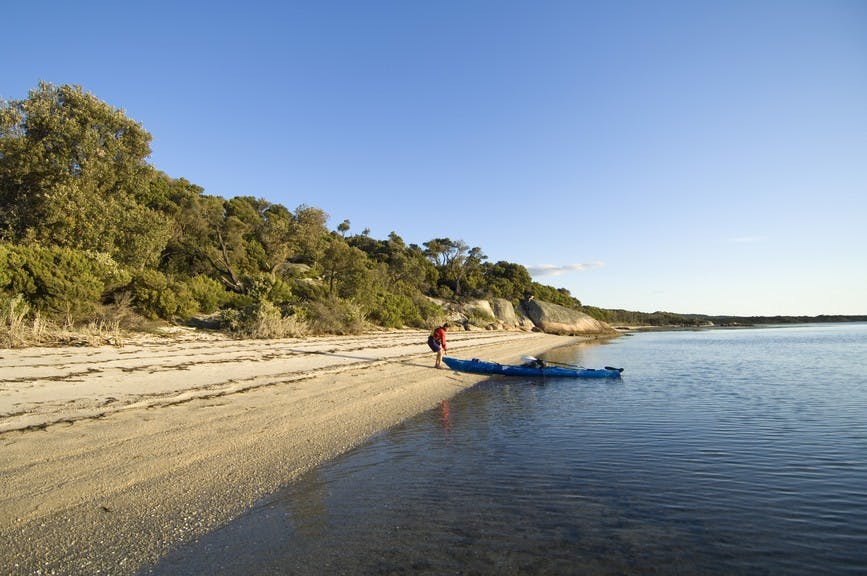 Man brings kayak ashore at Wilsons Promontory