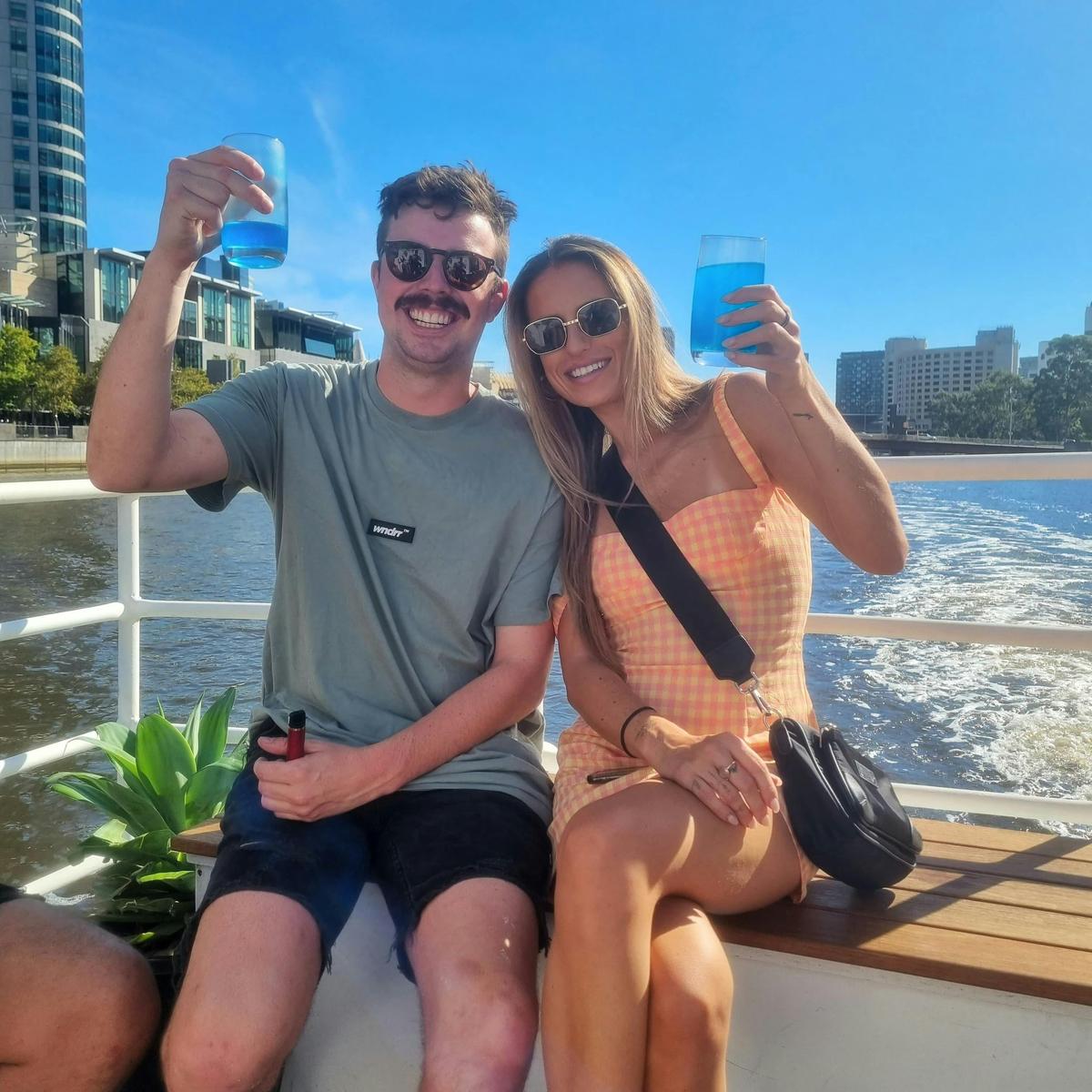 Couple holding up cocktails on the cruise