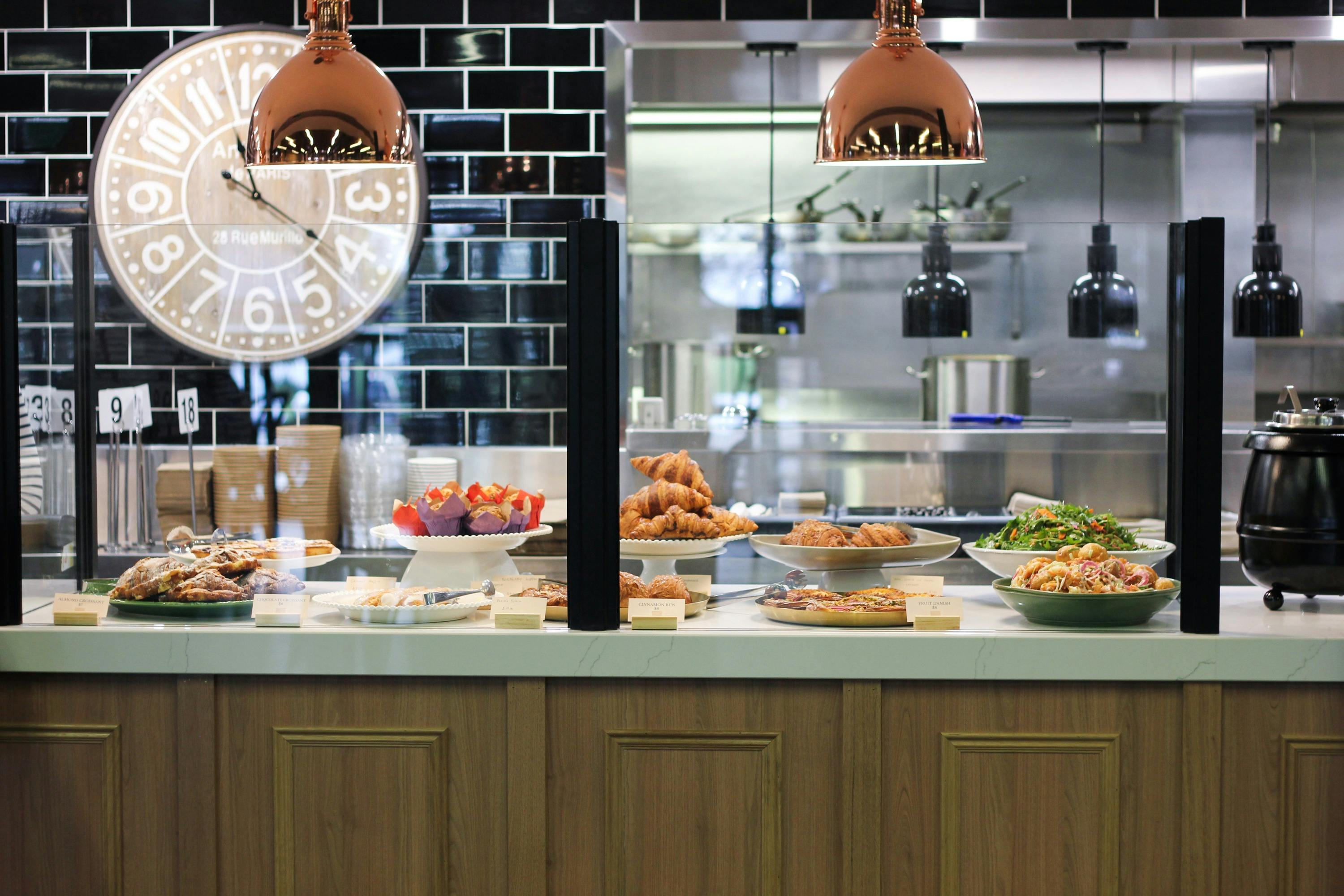 A selection of pastries, salads and sweets arranged on platters on a marble counter