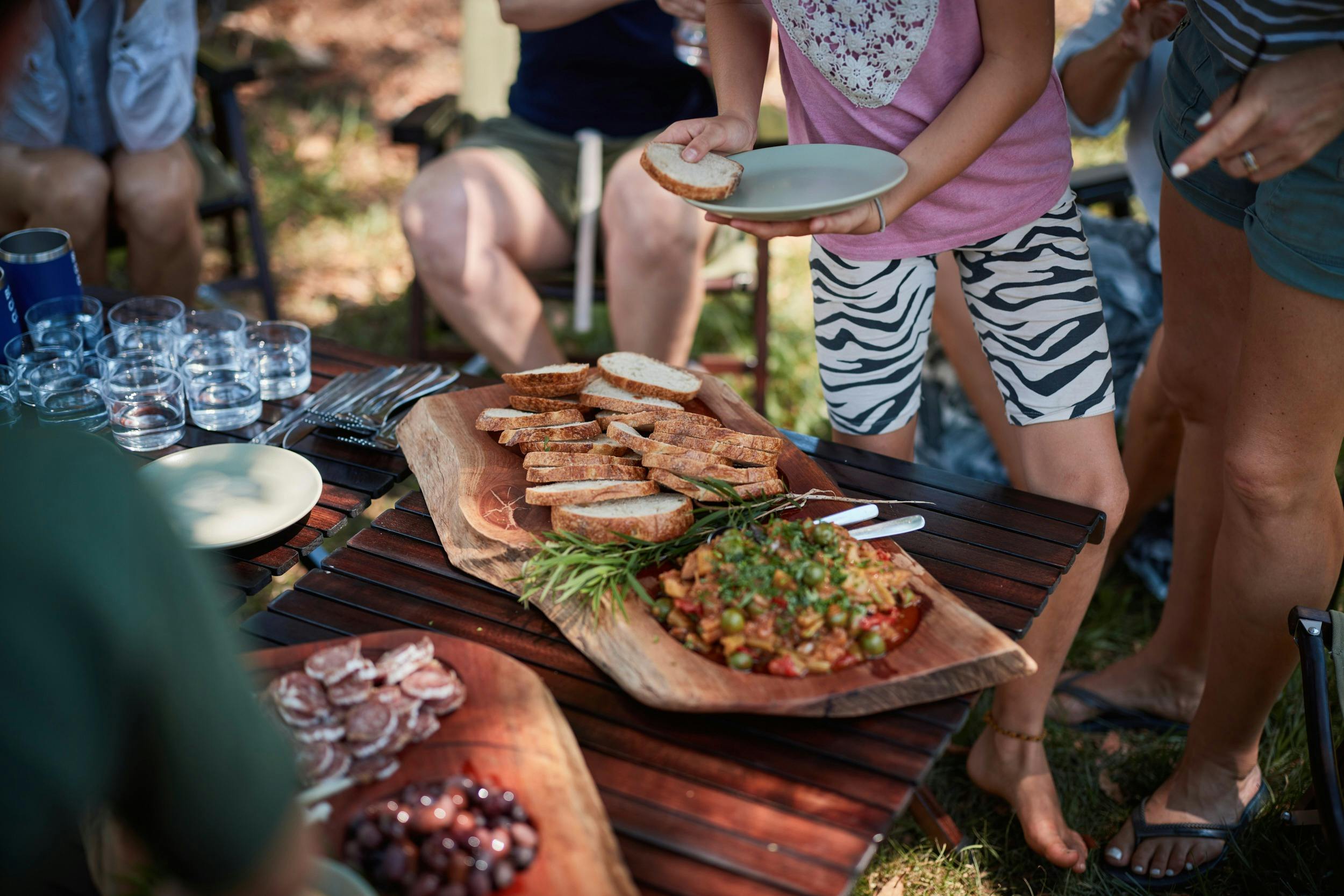 People gathered around a board of food