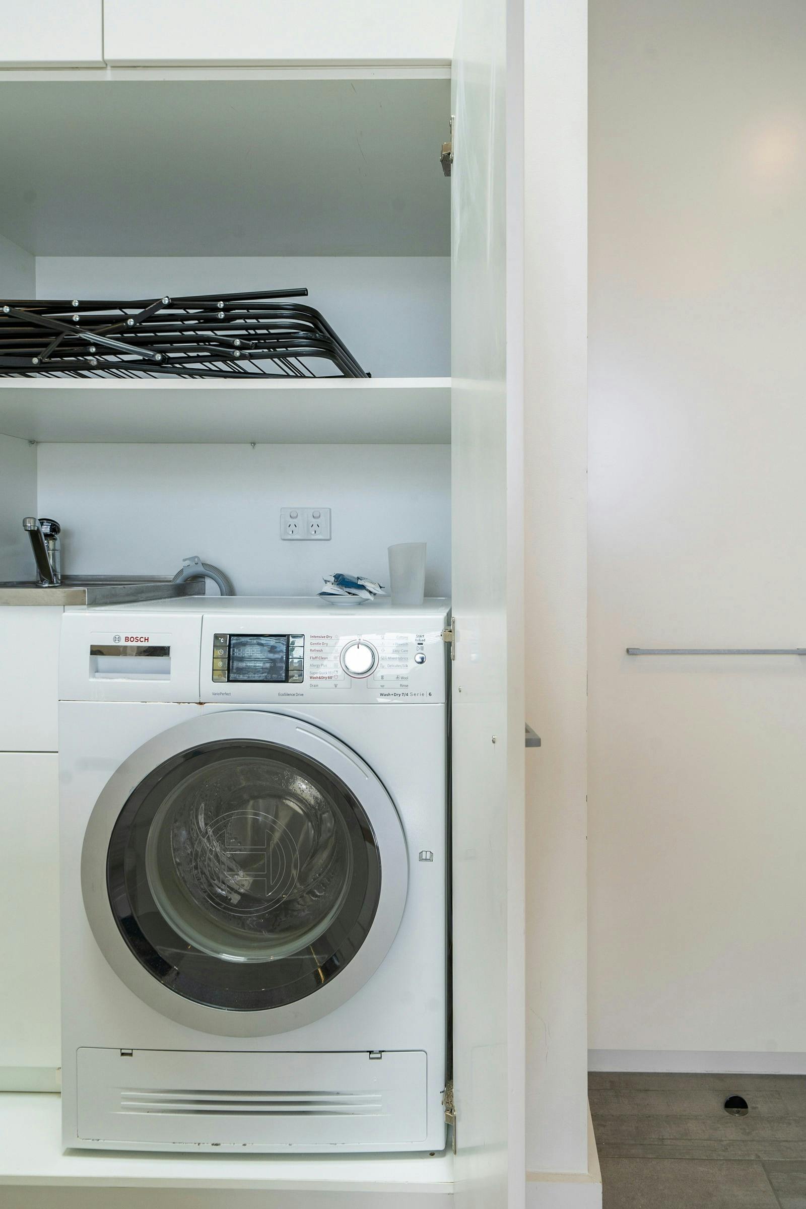 Modern bathroom with stylish finishes and a convenient laundry area.