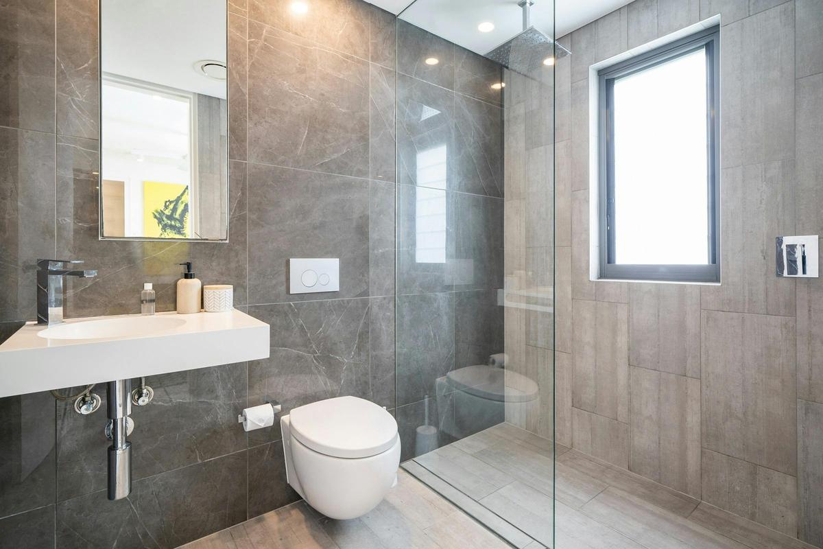 Modern bathroom with stylish finishes and a convenient laundry area.