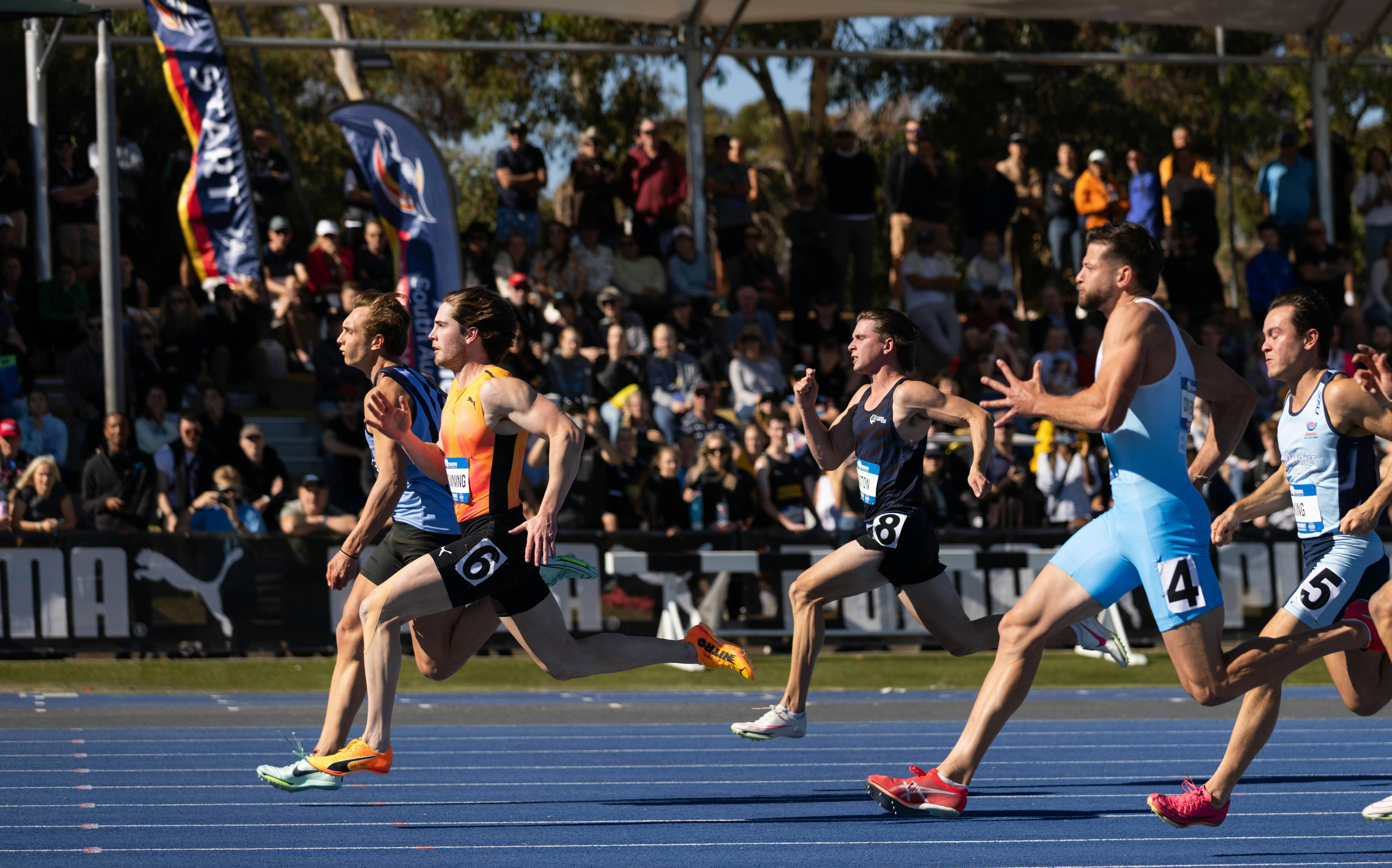 Athletes racing in the 100m Final