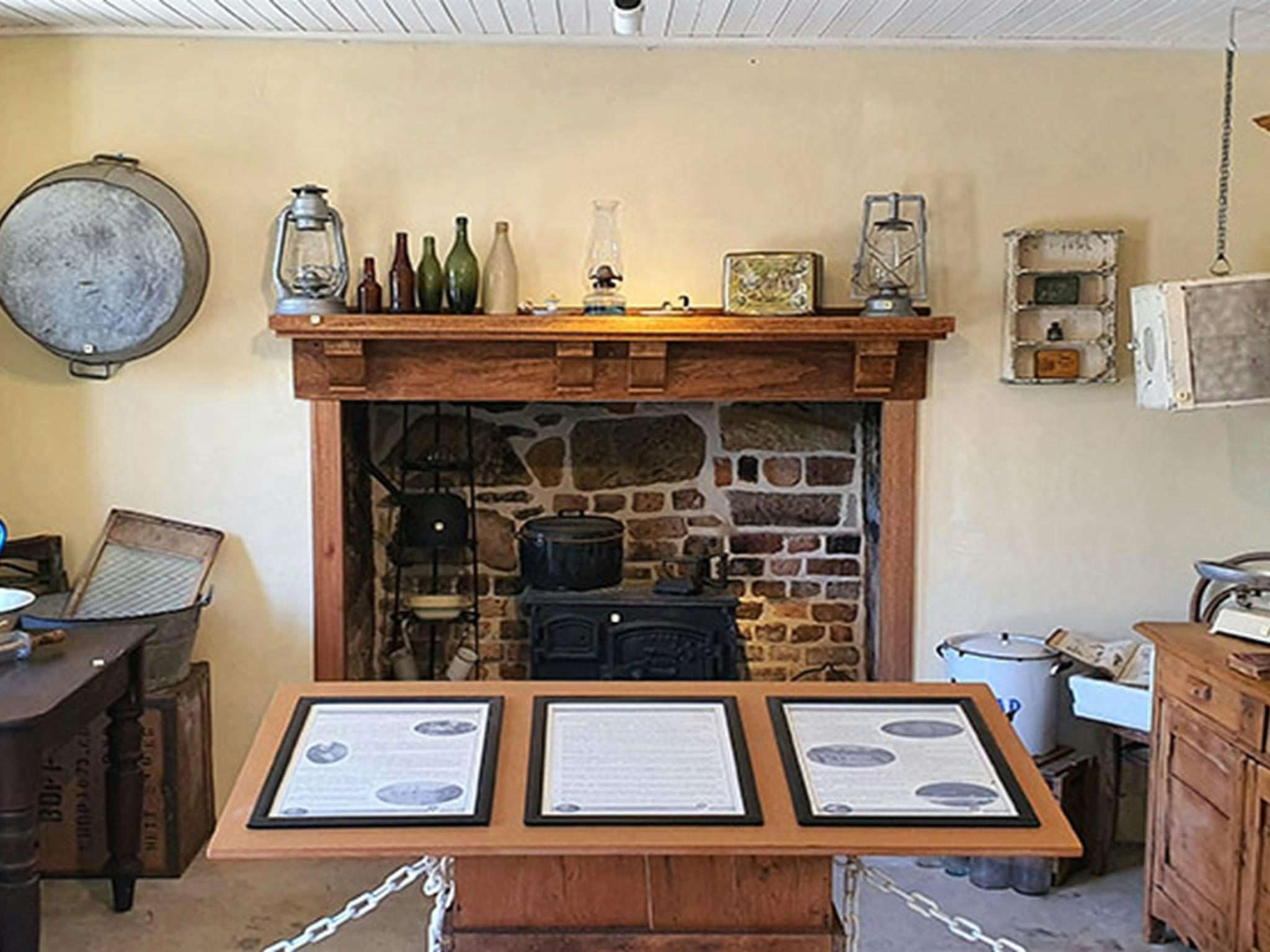 The western interior of Jenkins Kitchen with crockery and fireplace on display in Lane Cove National