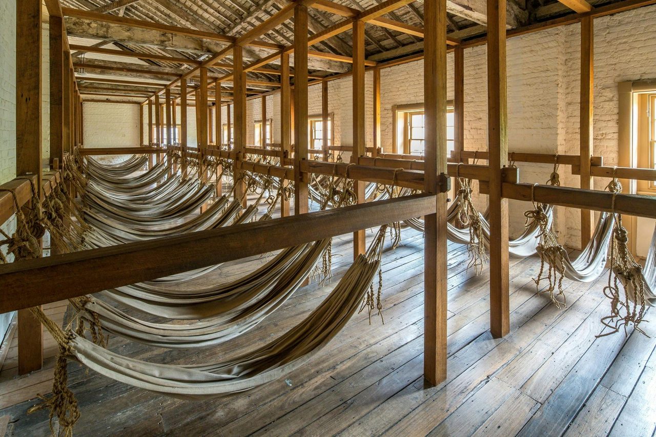 Historic room filled with canvas hammocks