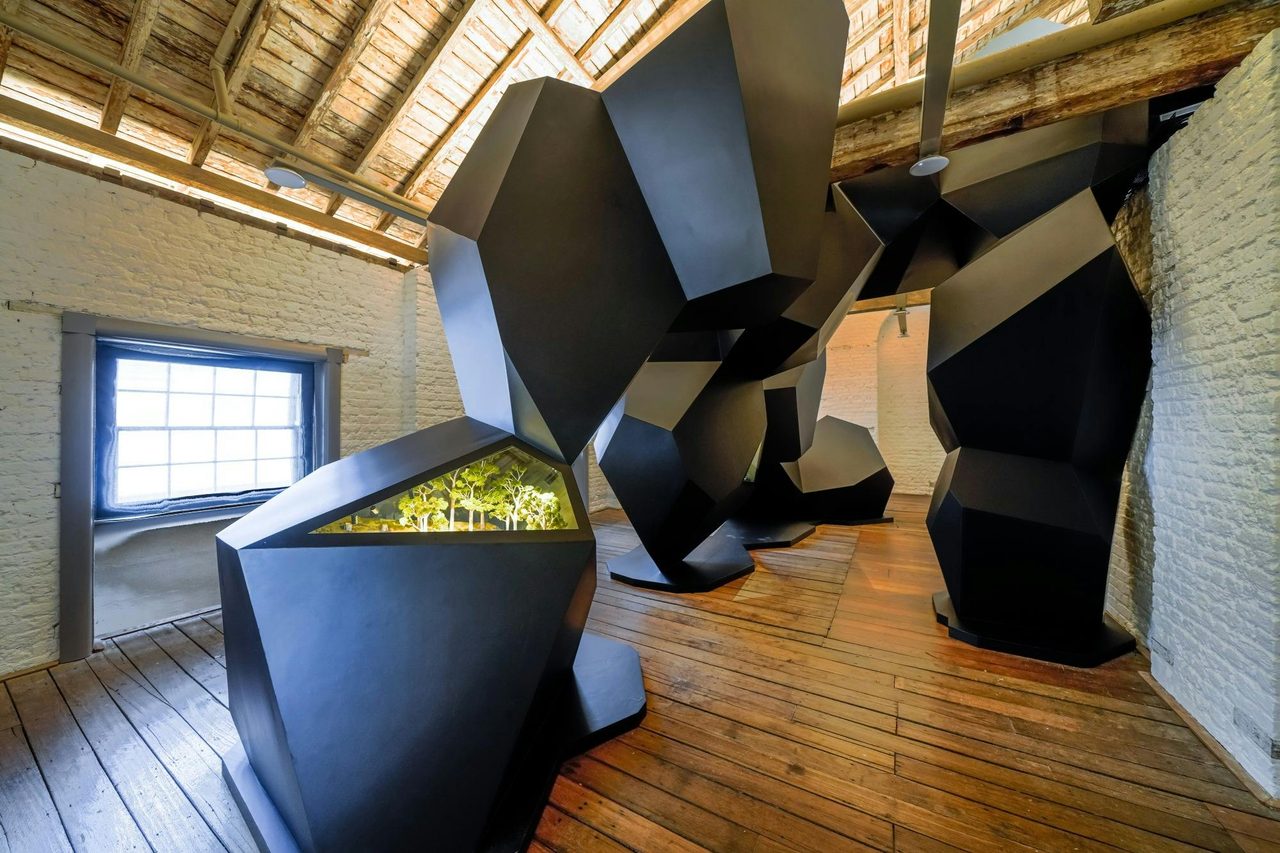 Black sculptural work with miniature models