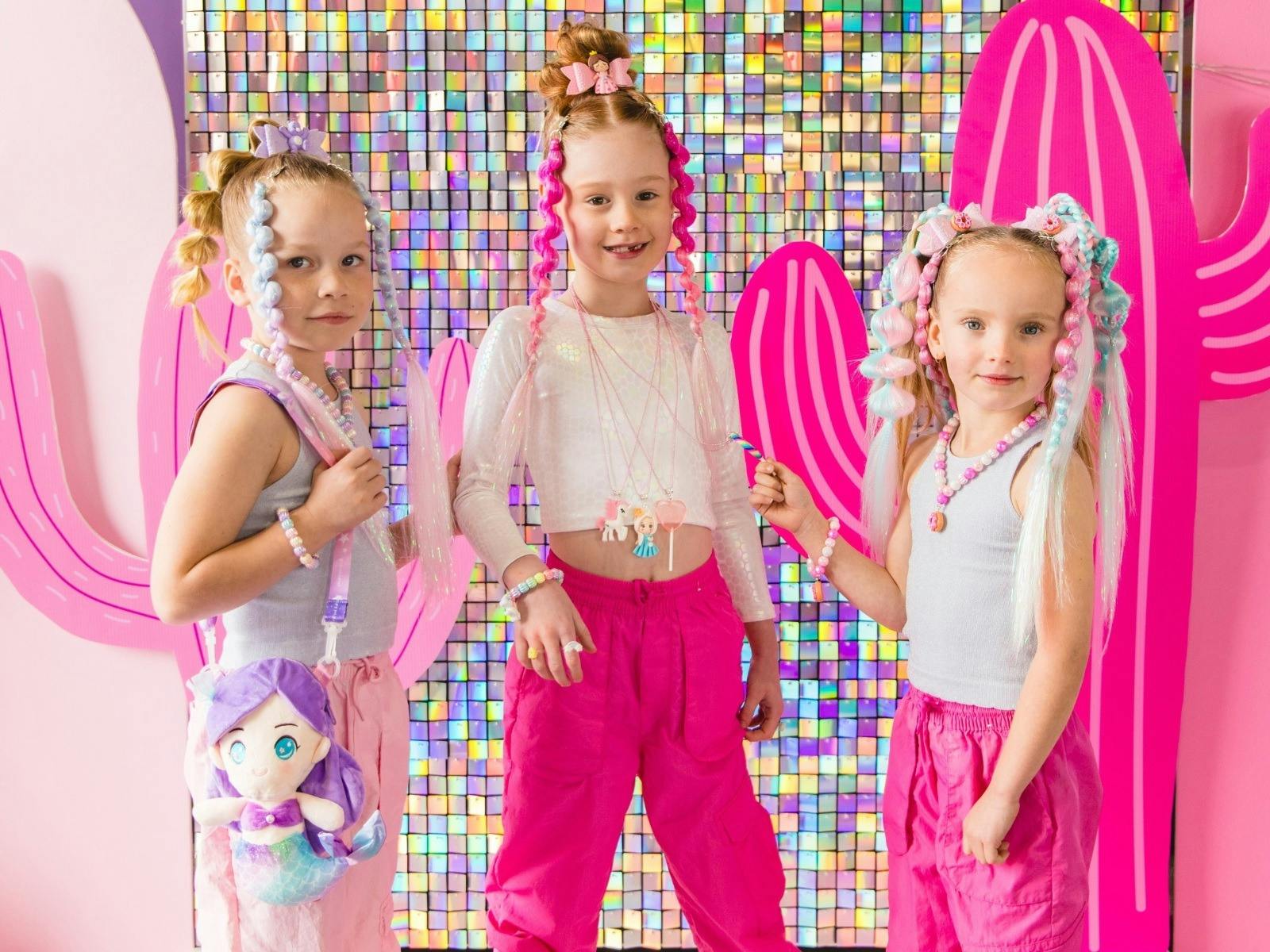 Three little girls with coloured hair manes in their pig tales.