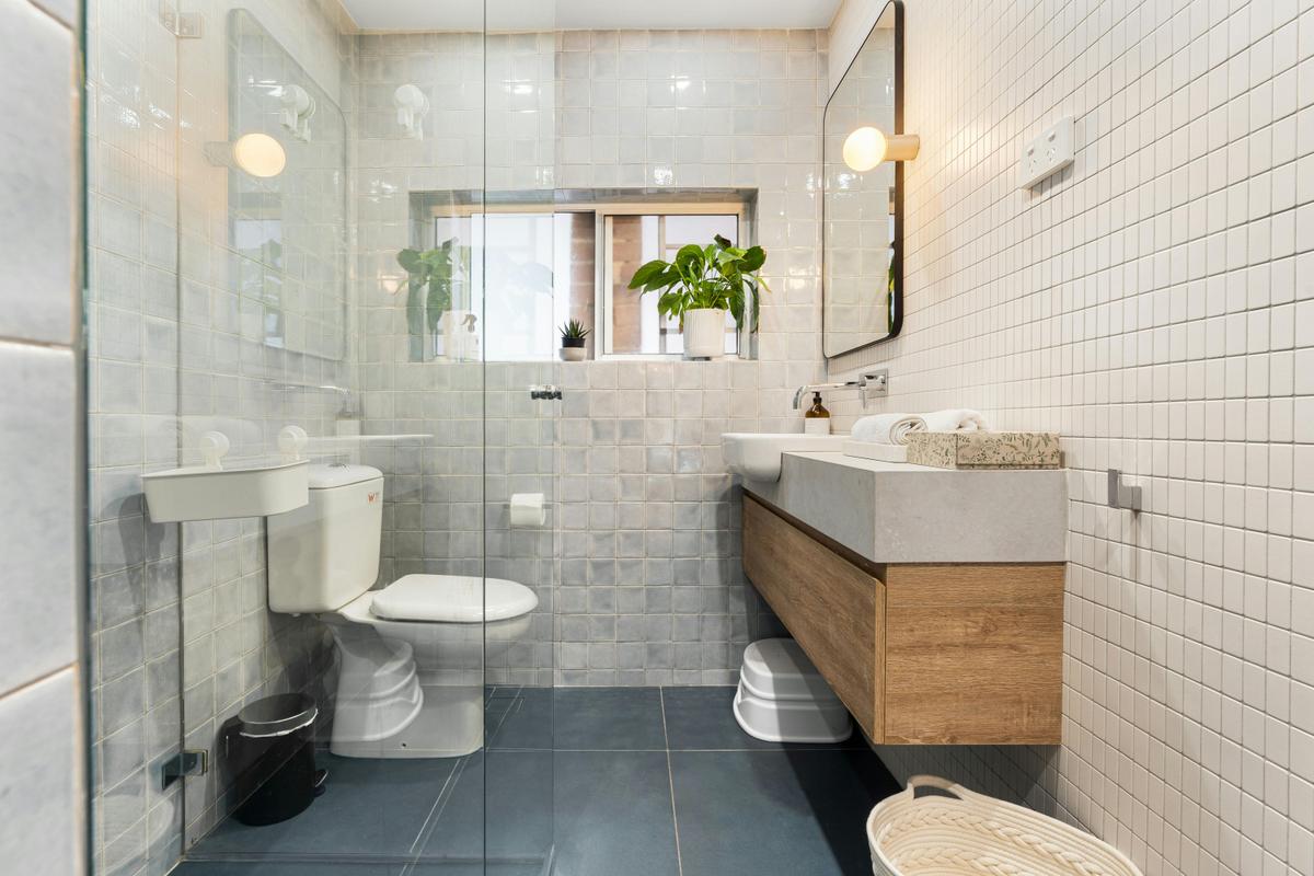 Contemporary bathroom with a sleek washer, modern fixtures, and natural light.