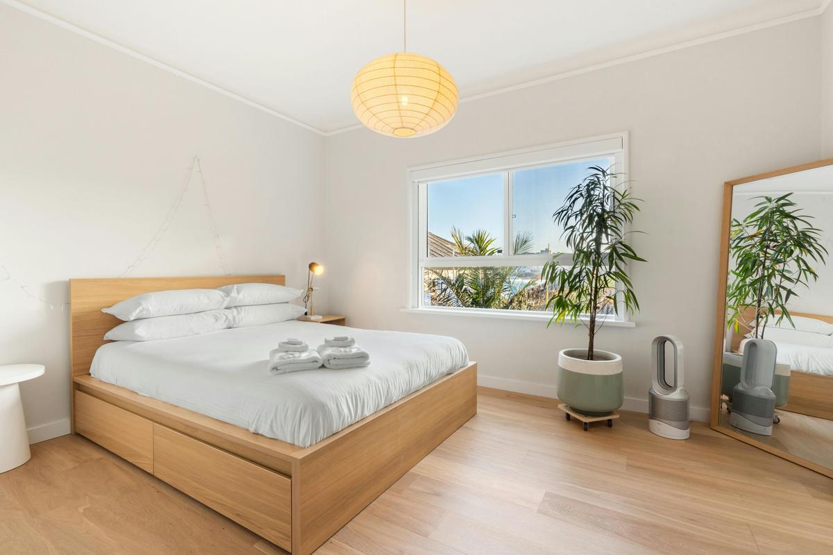 Cozy bedroom with natural light, stylish furnishings, and a calming atmosphere.