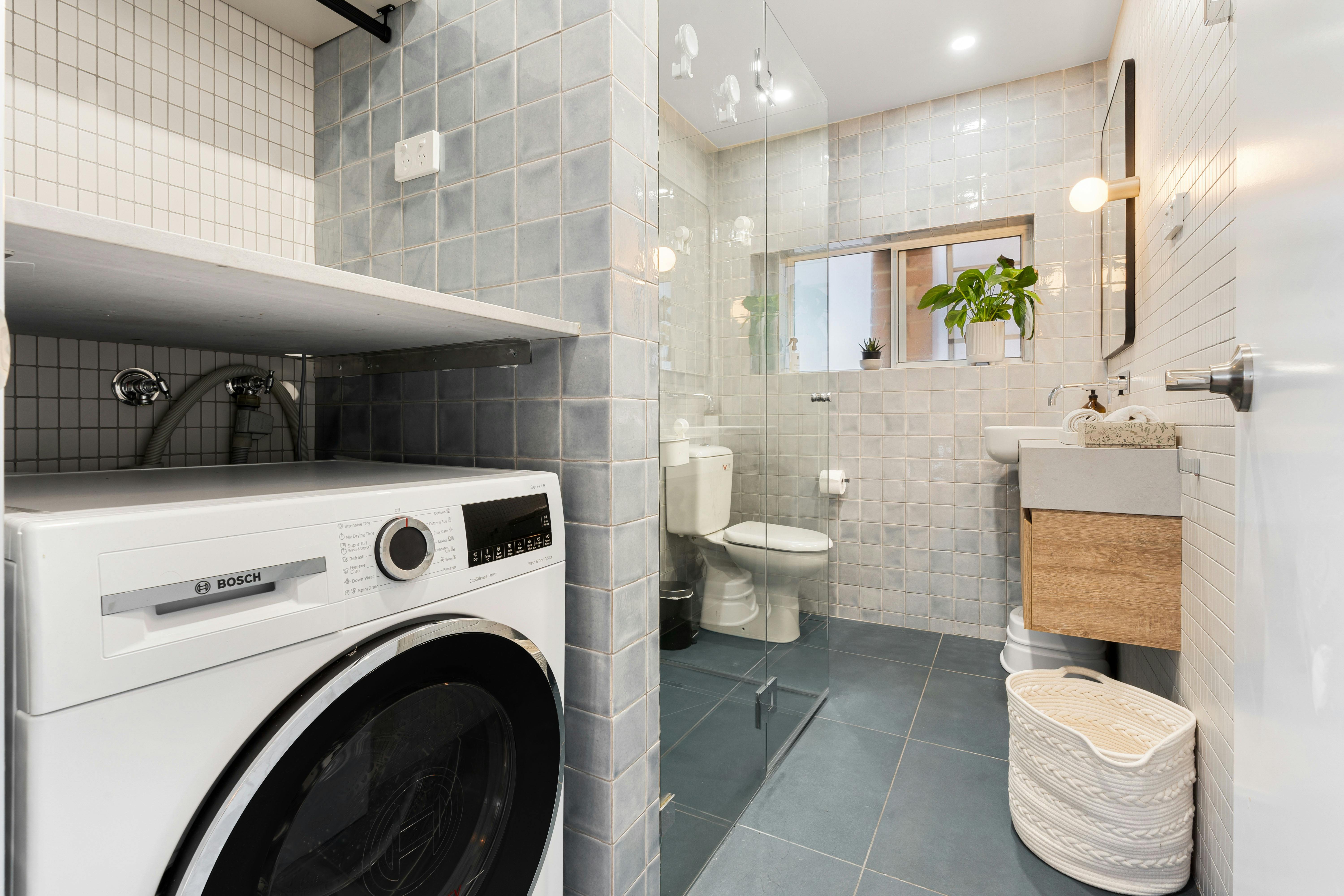 Contemporary bathroom with a sleek washer, modern fixtures, and natural light.