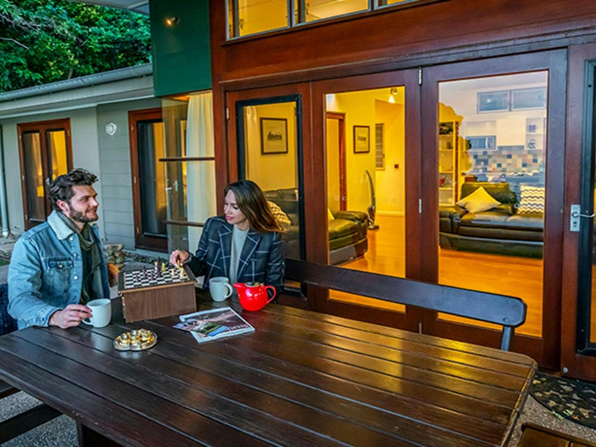 Guests playing chess with tea outside Mildenhall cottage. Photo: DPIE/John Spencer