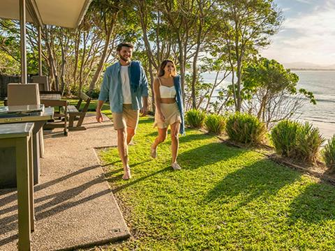 Couple walk through back garden by the beach at Mildenhall cottage. Photo: DPIE/John Spencer