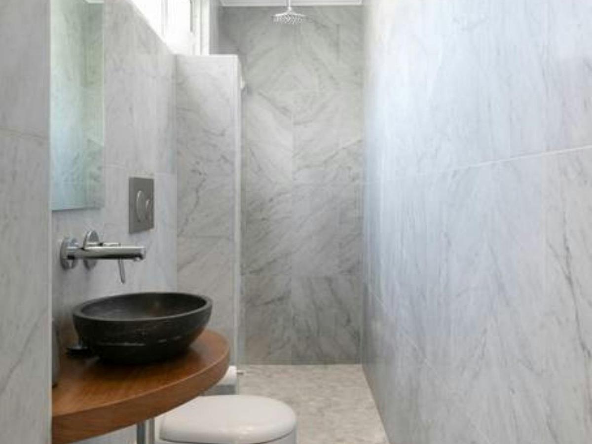 Modern bathroom with sleek marble finishes and a stylish stone sink.