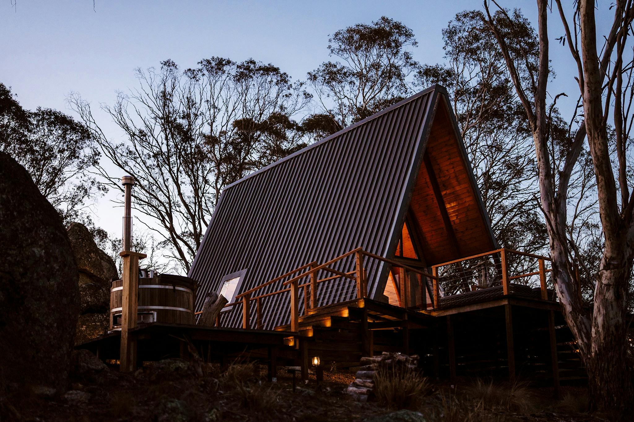 Exterior of Riverview A-Frame cabin with wood-fired hot tub on deck overlooking river
