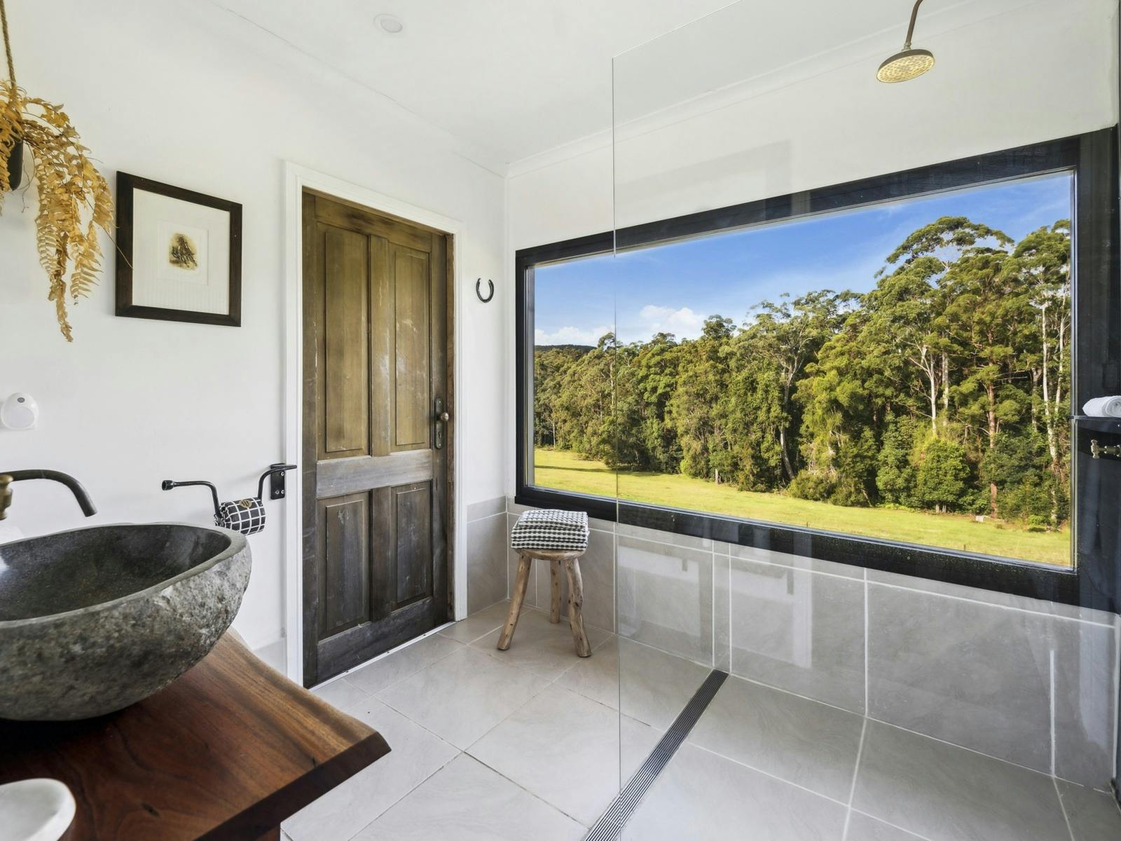 Rain shower bathroom with forest views at The Hitching Rail Hut, Coramba NSW