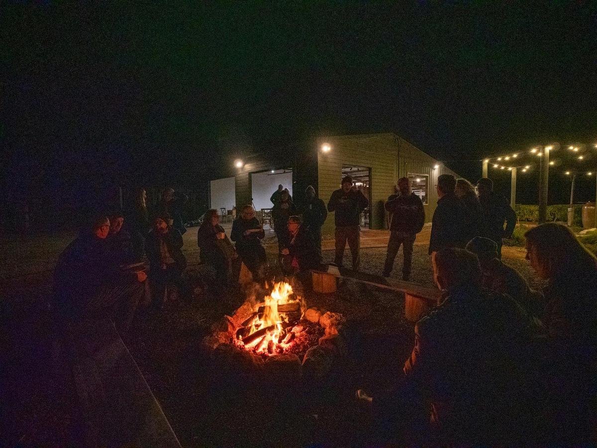 Guests enjoying dinner by the campfire