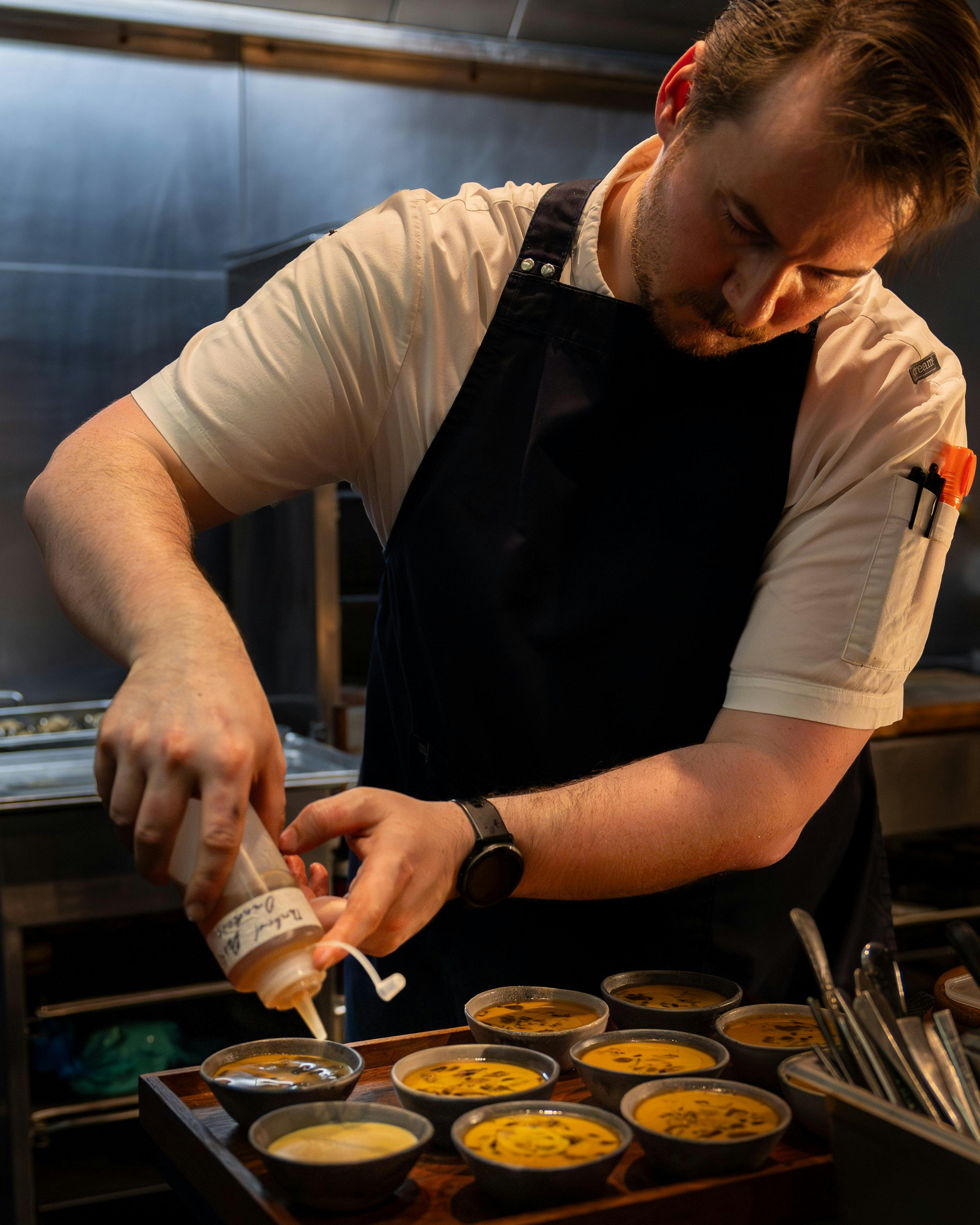 Joshua Hannan (chef) preparing dish.