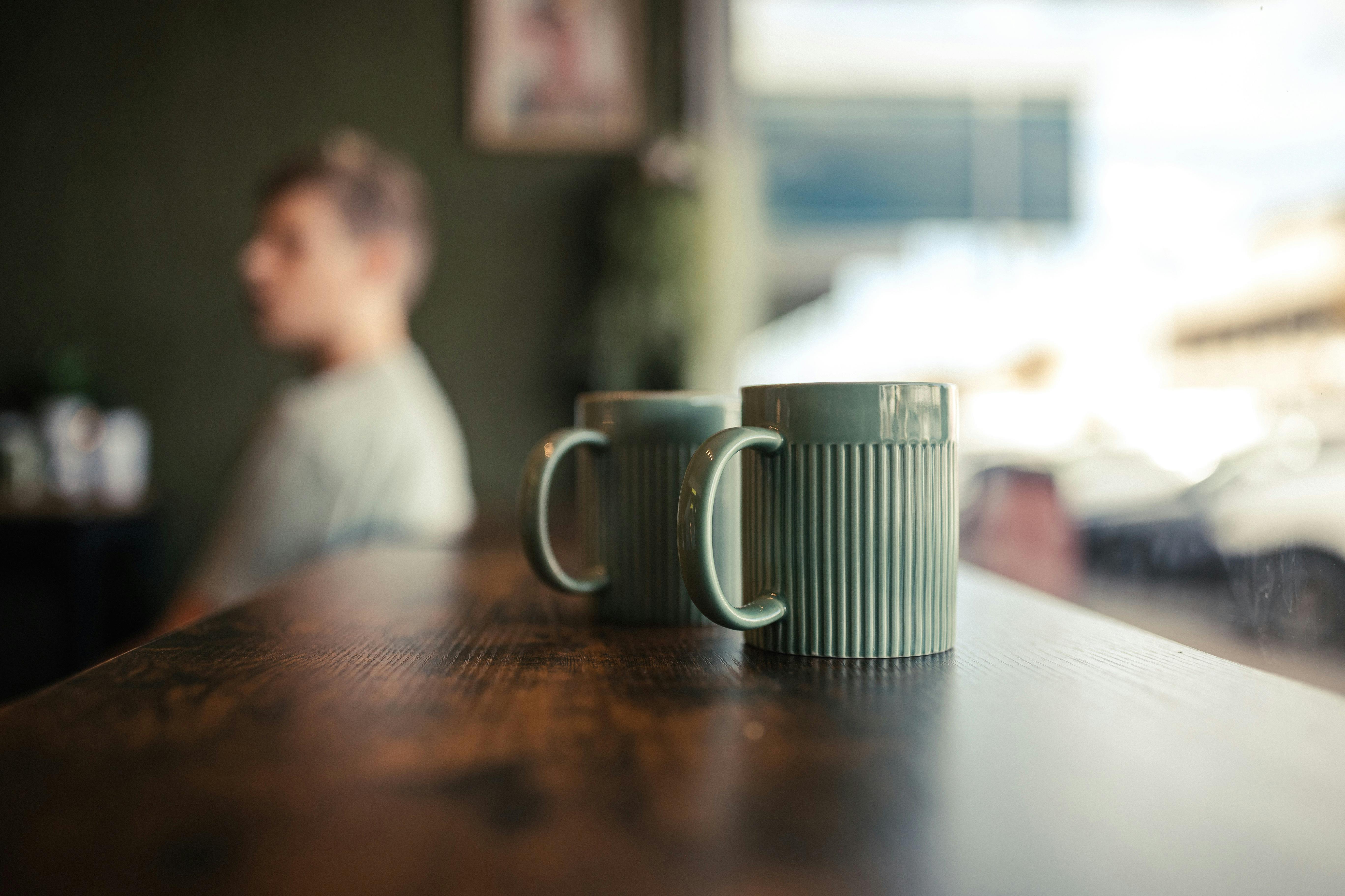 Mugs on bench facing window out to the street