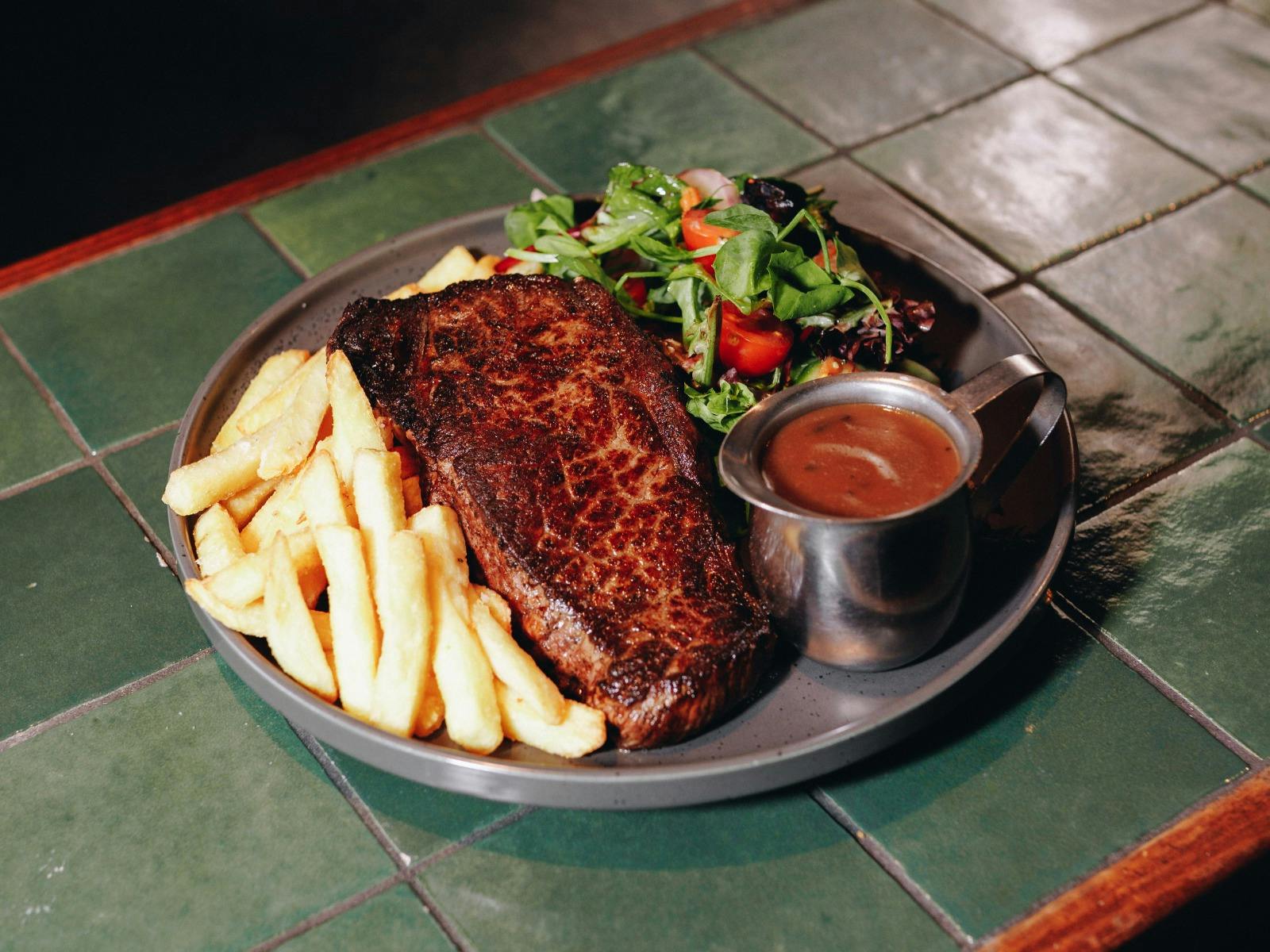 Grilled steak with chips, salad and gravy.