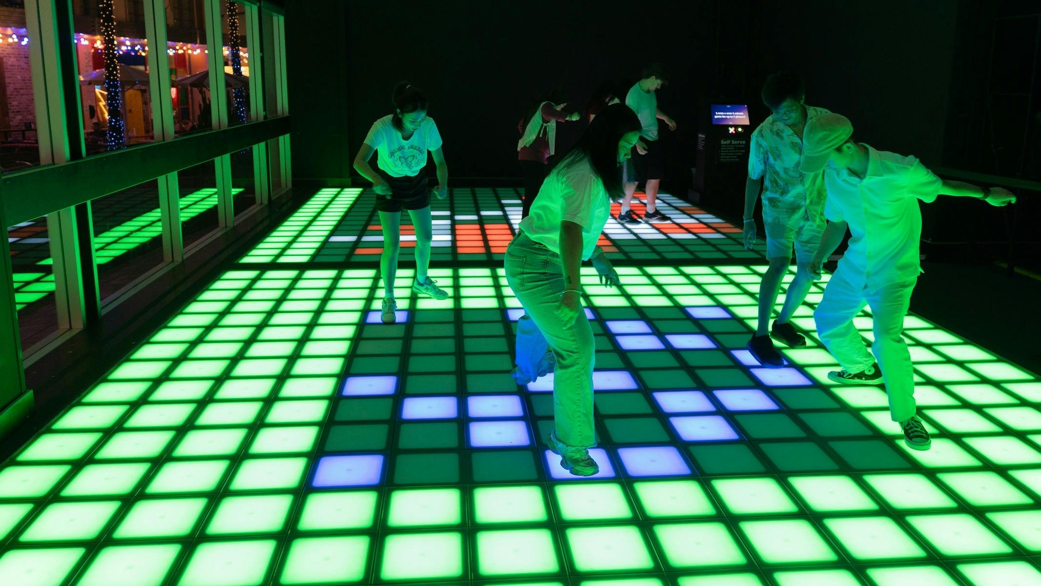 Multiple patrons playing Pixel at night