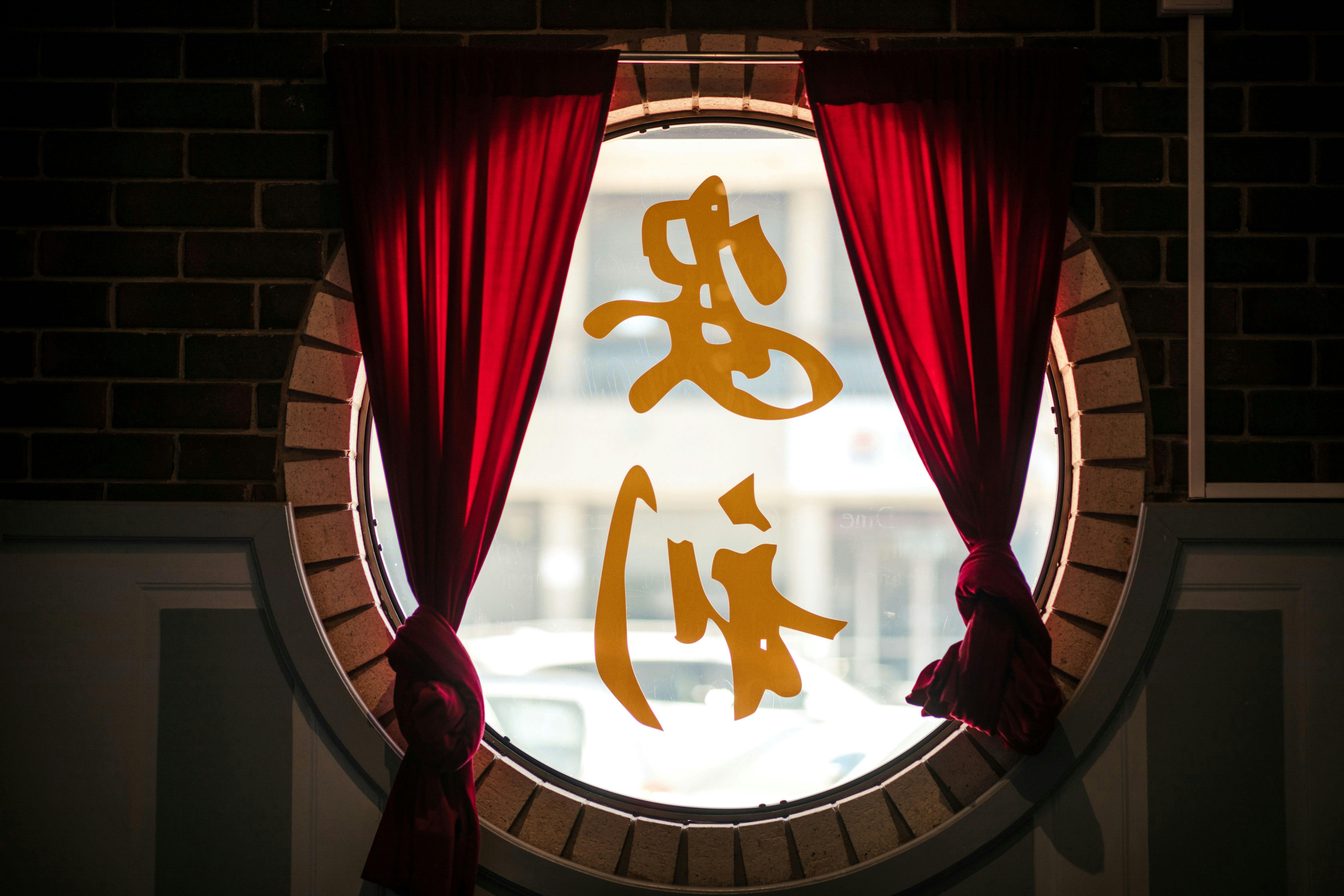 Window of the chinese restaurant with red curtains