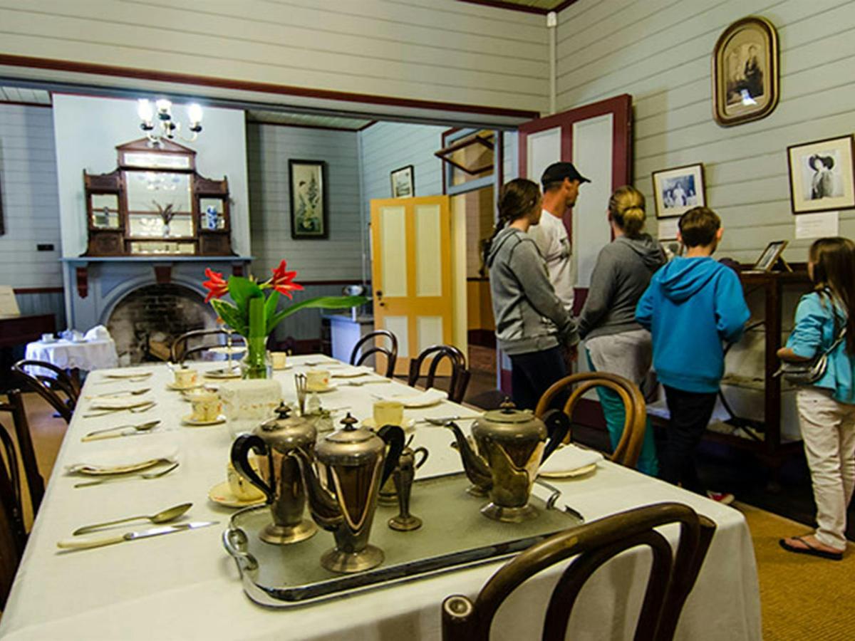 A group of people look at photos on the wall of the dining room in Roto House, nearby Macquarie