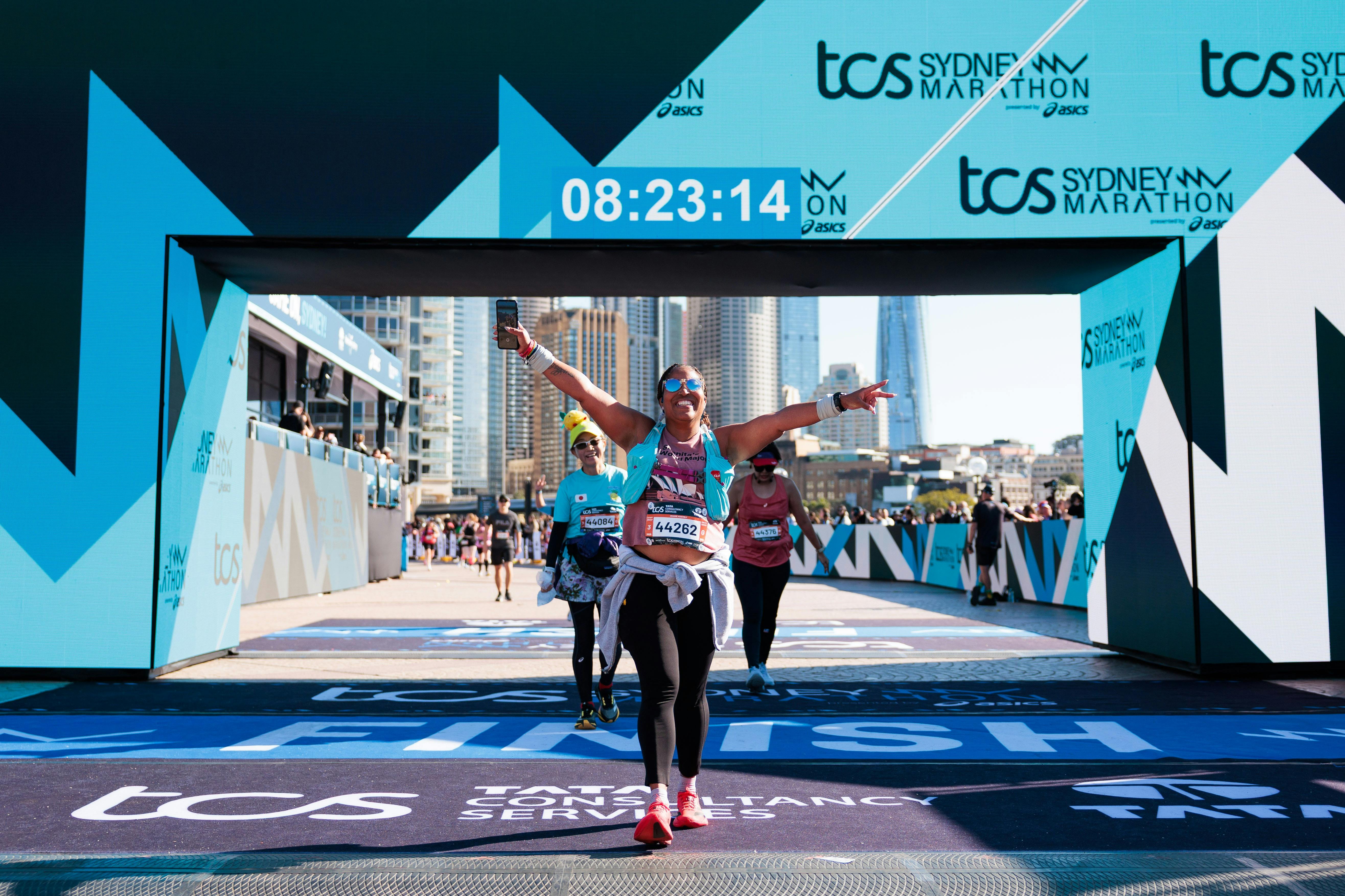 Marathon runner celebrating at the Opera Housefinish line