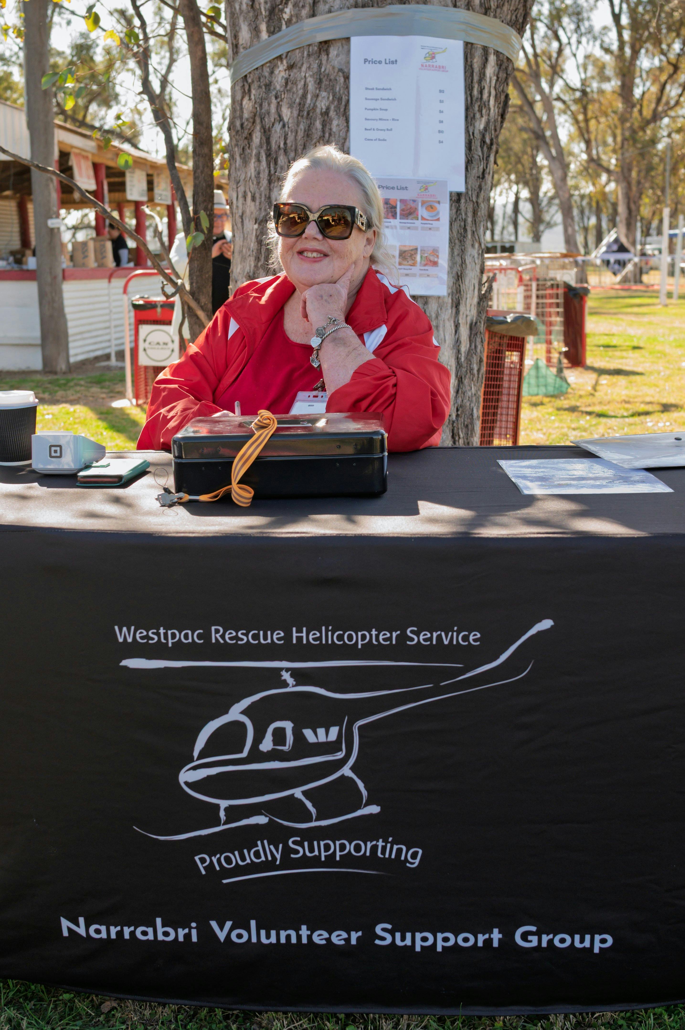 Volunteer from Westpac Chopper smiles at Wean Races selling food