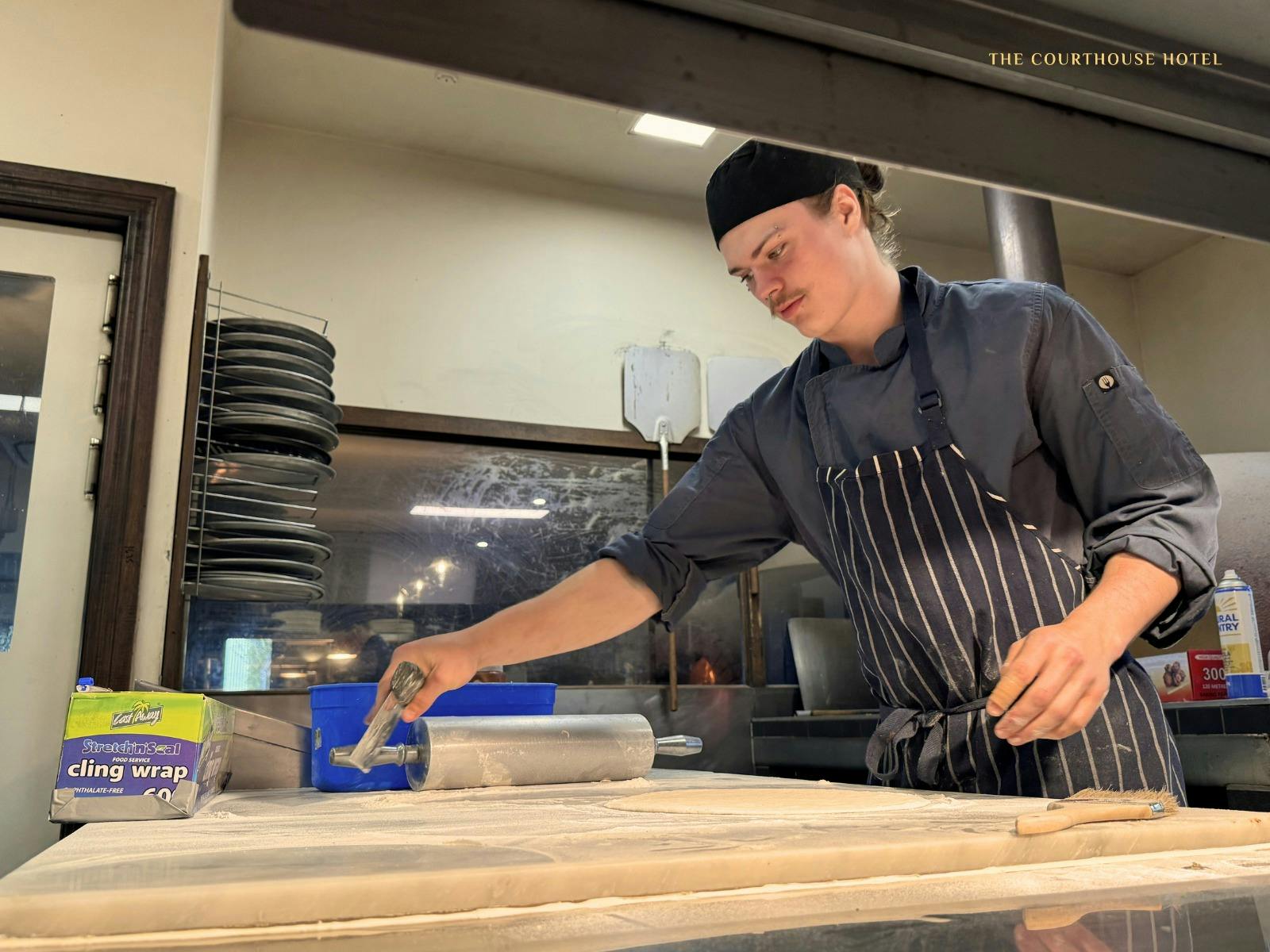 Chef preparing fresh ingredients in the kitchen at the Courthouse Hotel.