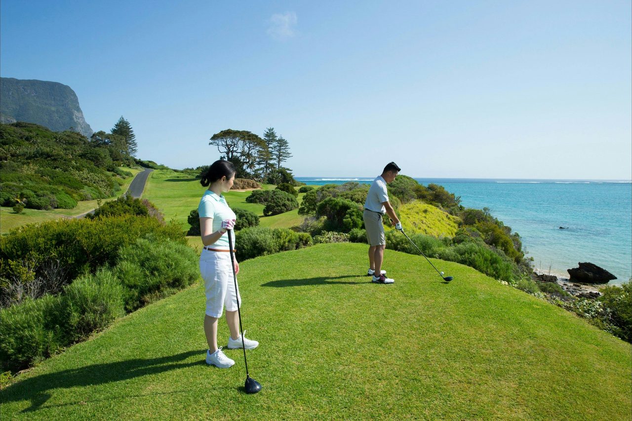 Couple enjoying a round of golf at Lord Howe Island Golf Course with ocean views