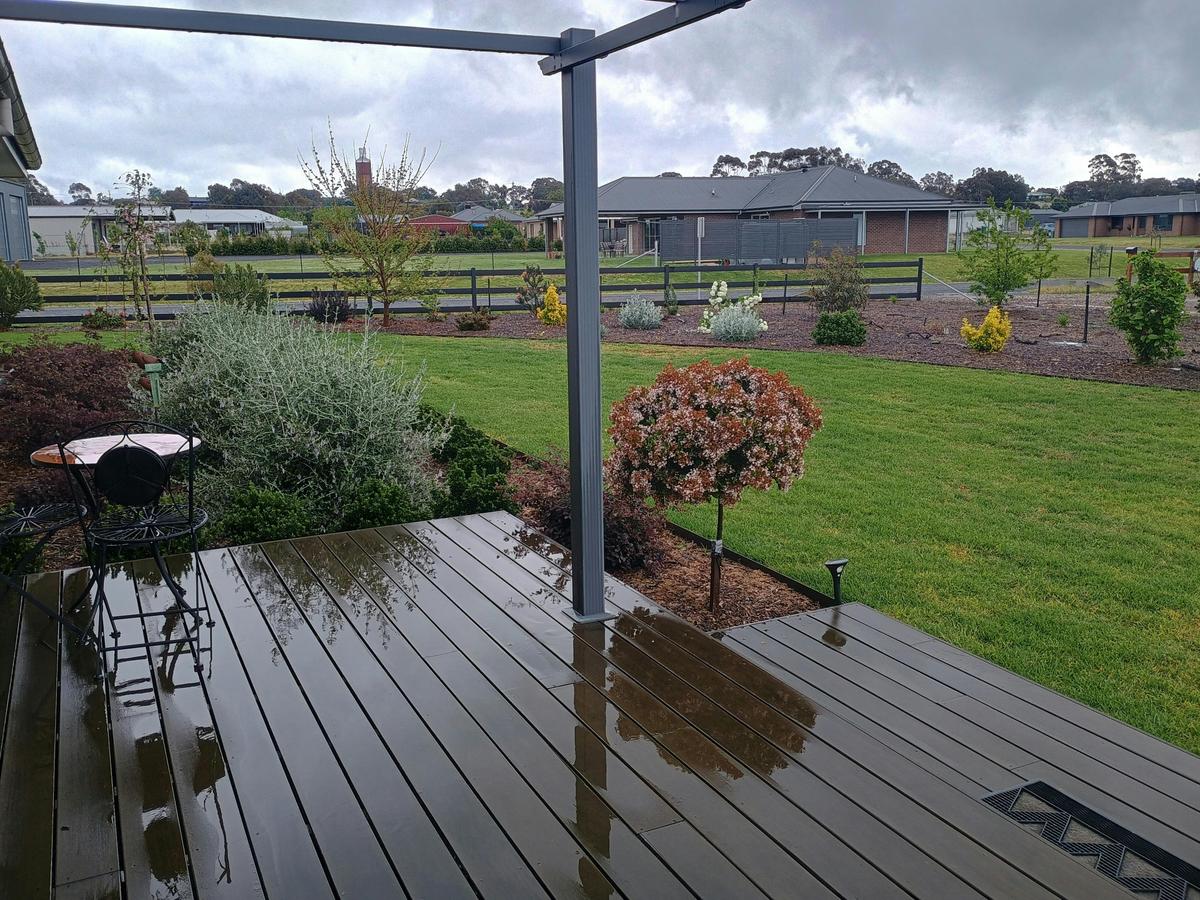 A wooden deck overlooking the garden and the Rutherglen Wine Bottle