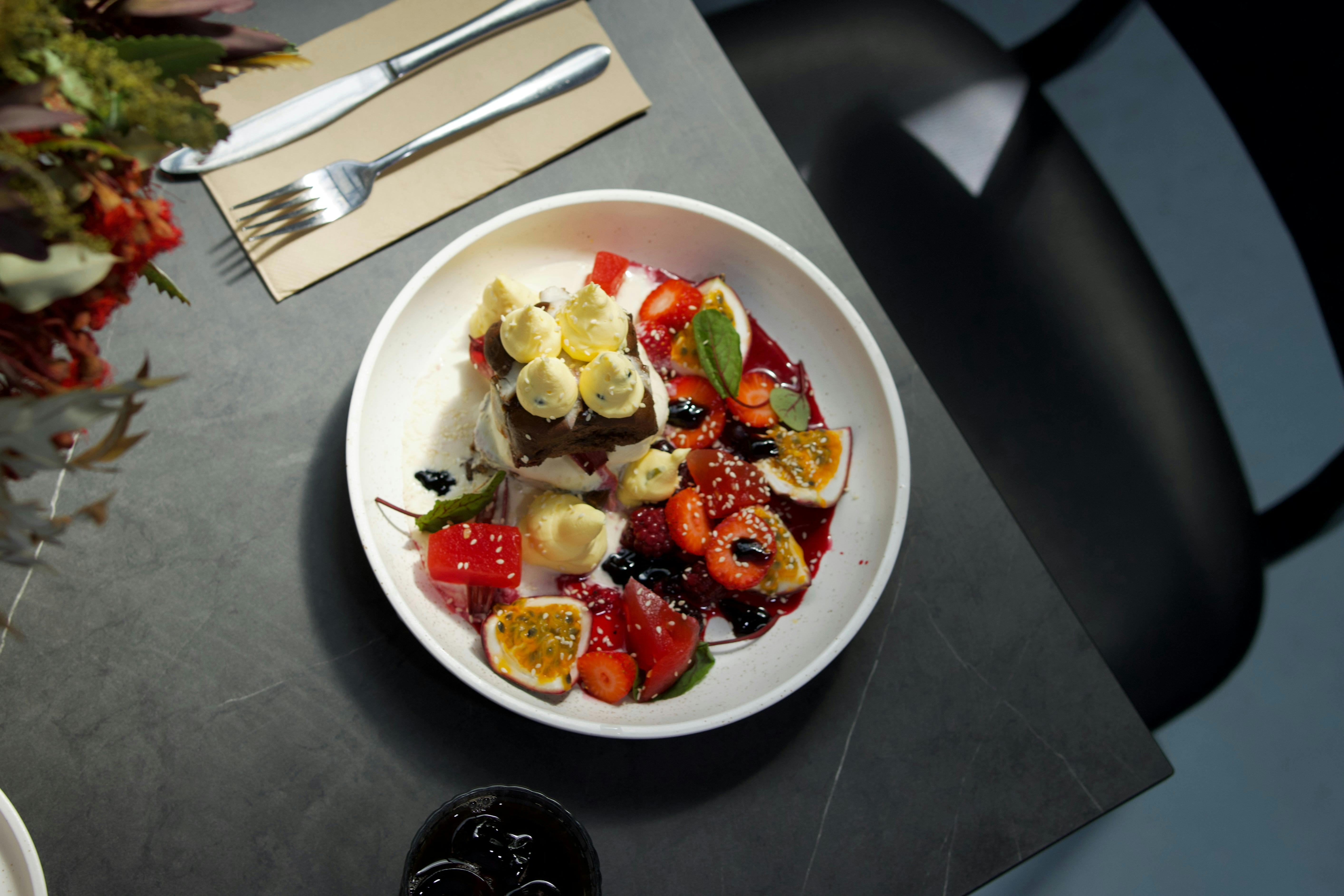 Desert dish plated on elegant dark table with flowers