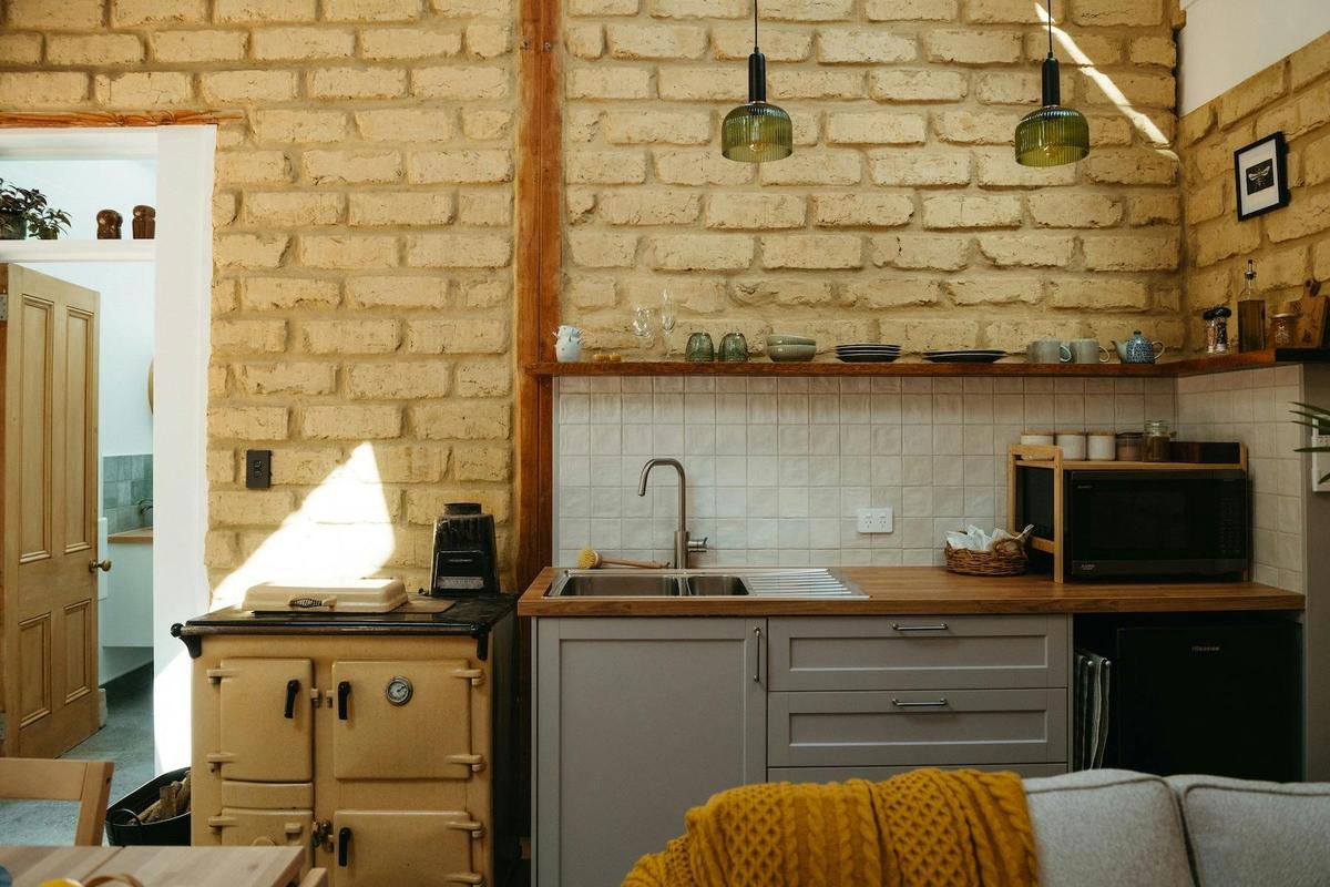 The kitchen has a microwave, an induction cooktop, bar fridge and well stocked with other items.