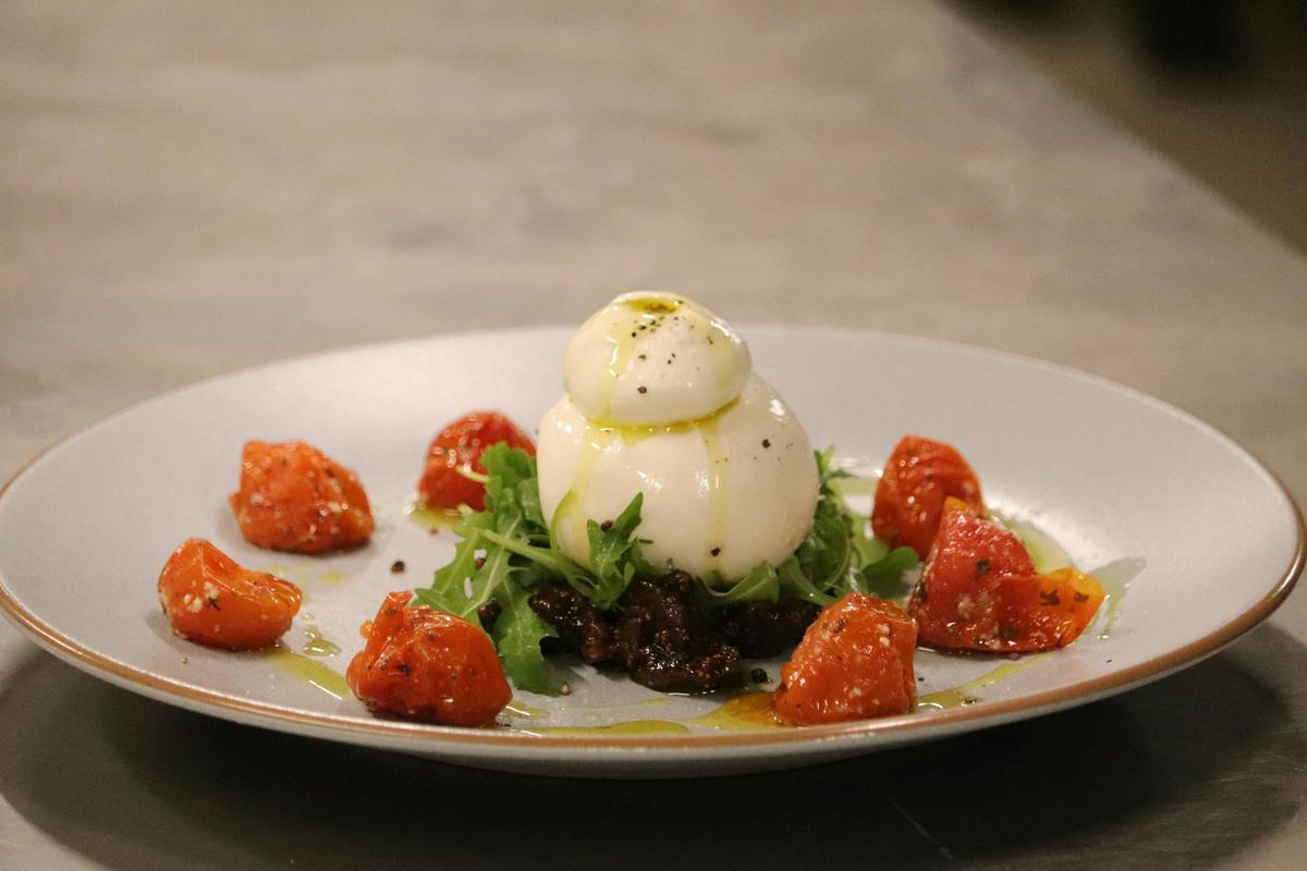 Creamy burrata layered over fresh greens and sweet roasted tomatoes, finished with a drizzle of oliv