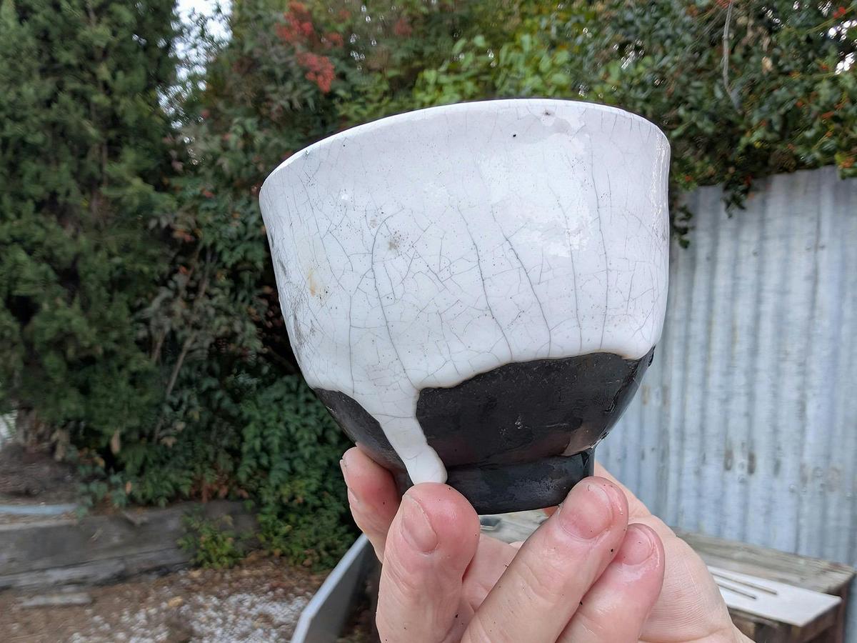 A finished black and white Raku pot