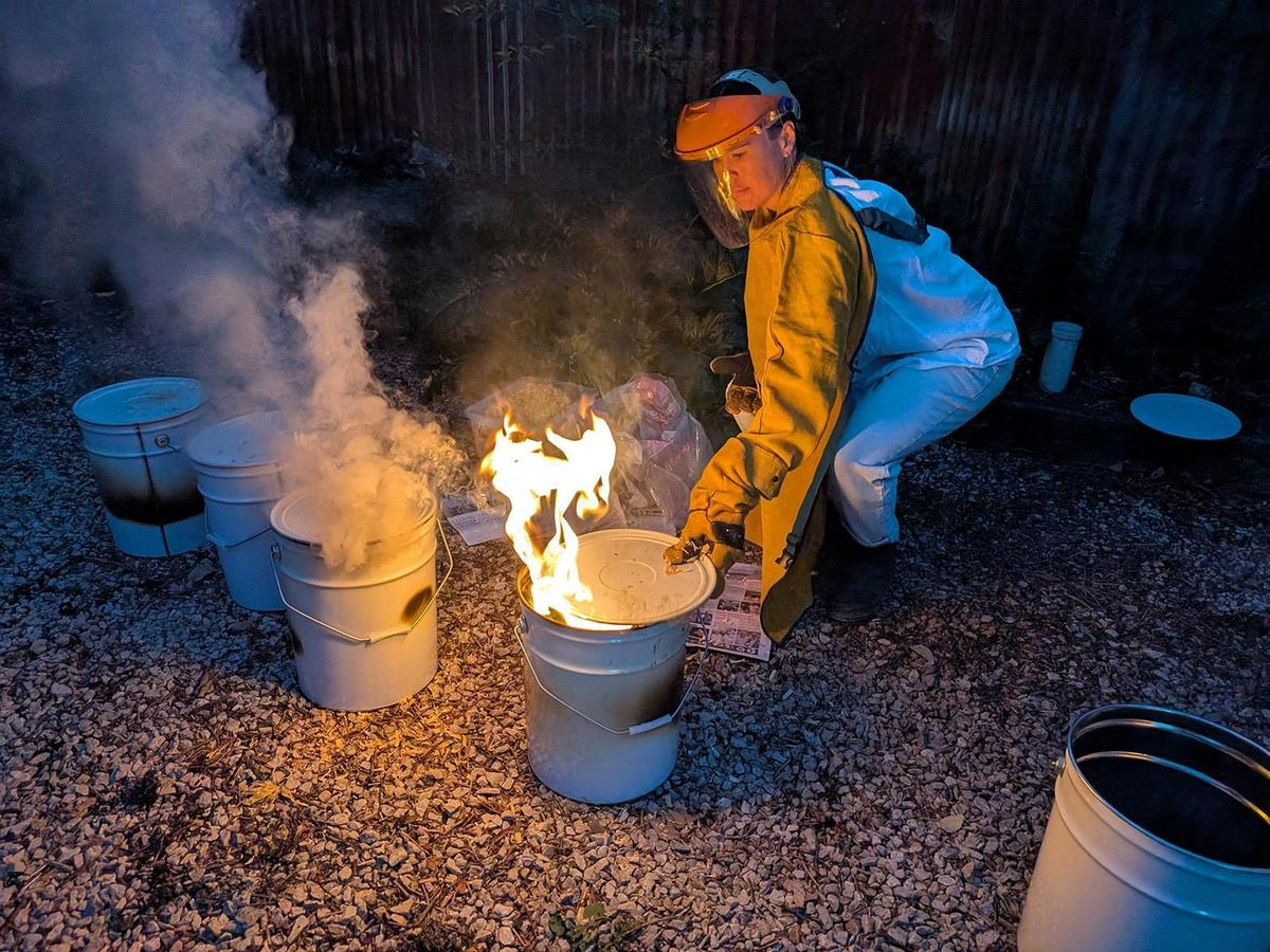 Placing a red hot pot into a bucket of combustibles