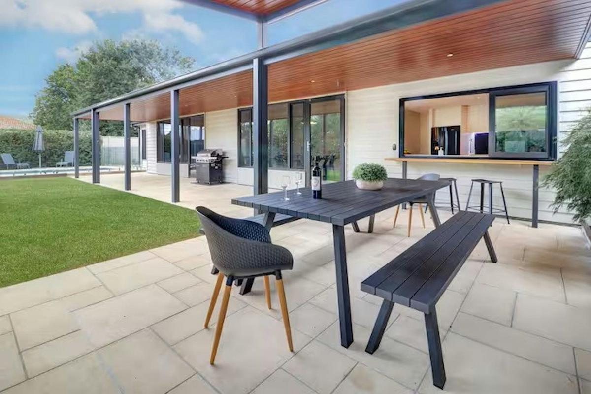 overed alfresco dining and BBQ area overlooking lawn and pool at Banksia House High Country Retreat