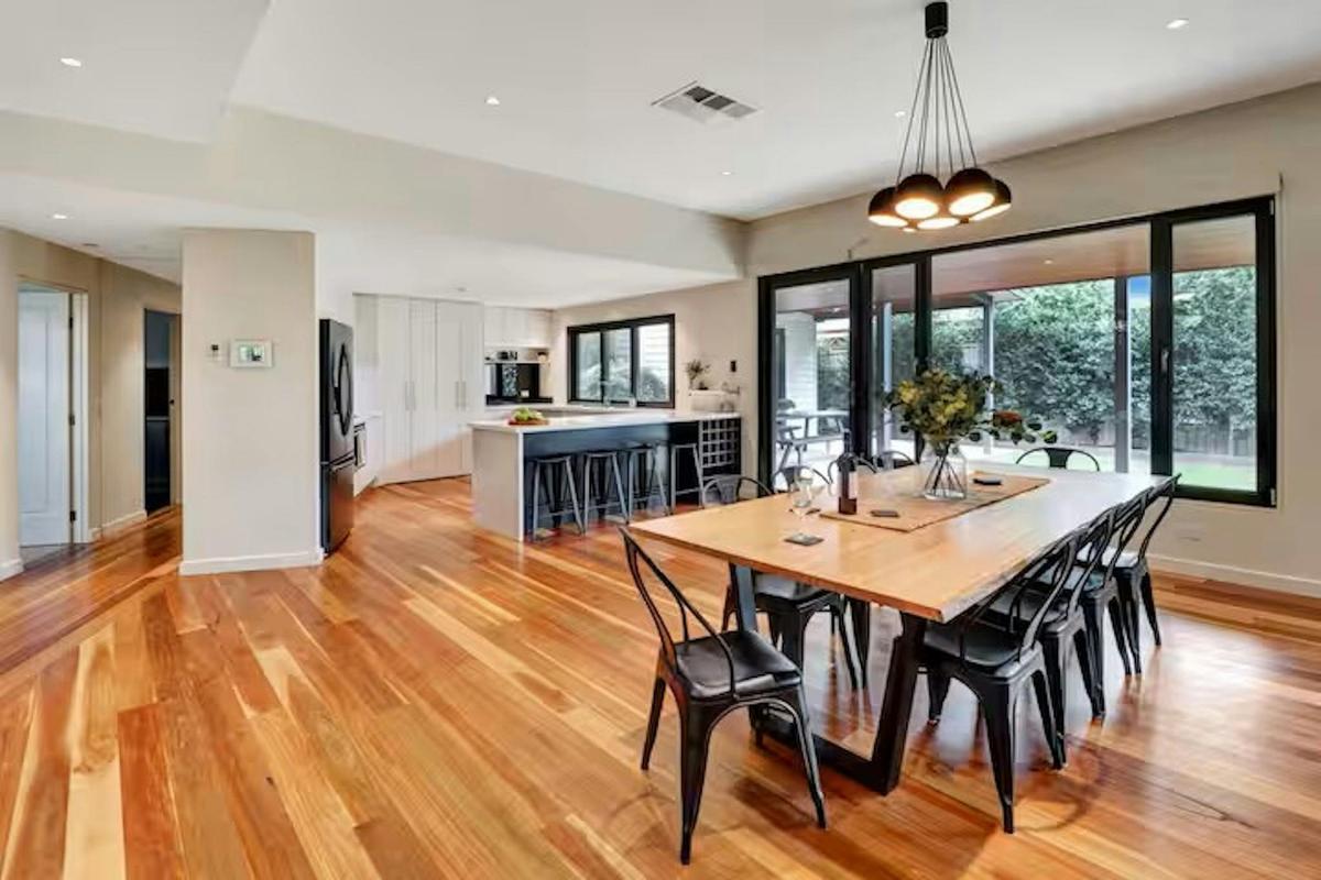 Spacious open plan kitchen and dining area with large island bench and garden outlook Banksia House