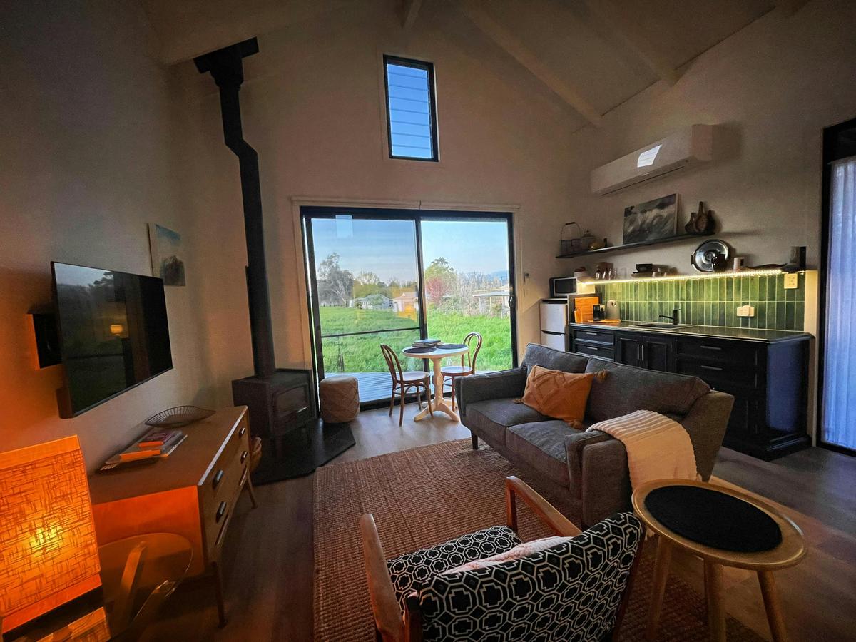 Cozy living space with wood burner and access to the private deck
