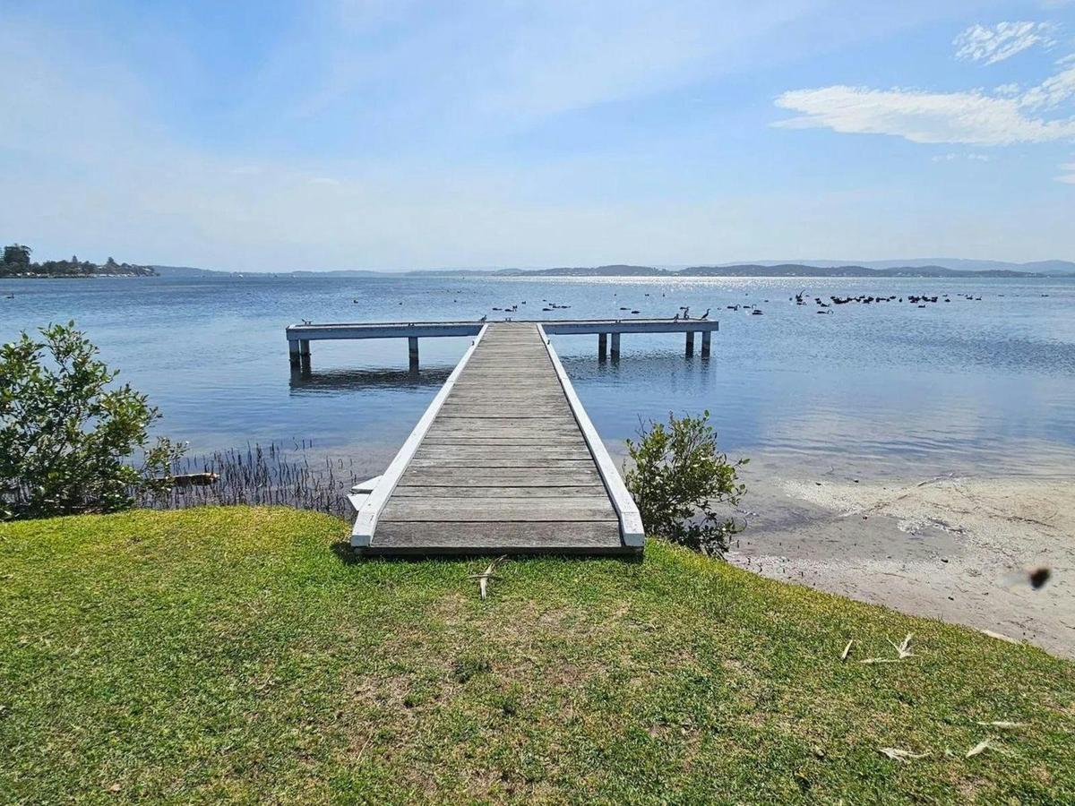Private jetty extending into Lake Macquarie with panoramic lake views.