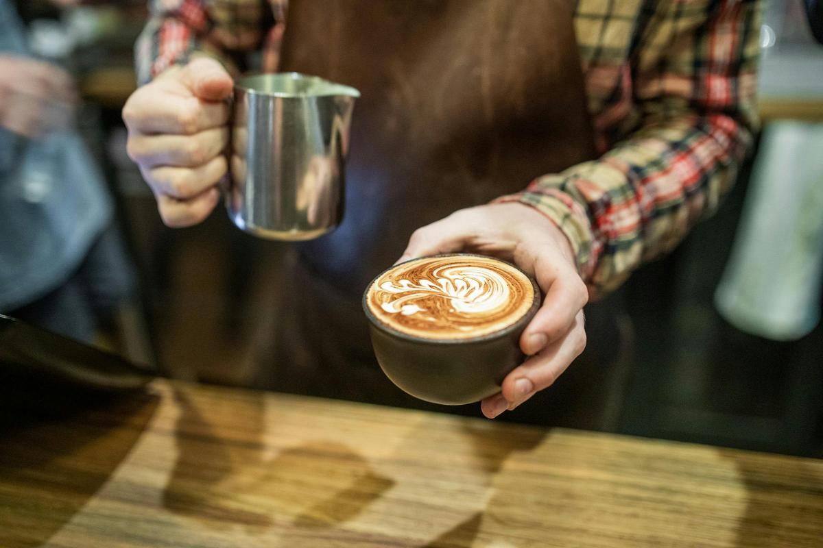 Barista pouring specialty coffee at Webster's Market and Cafe.