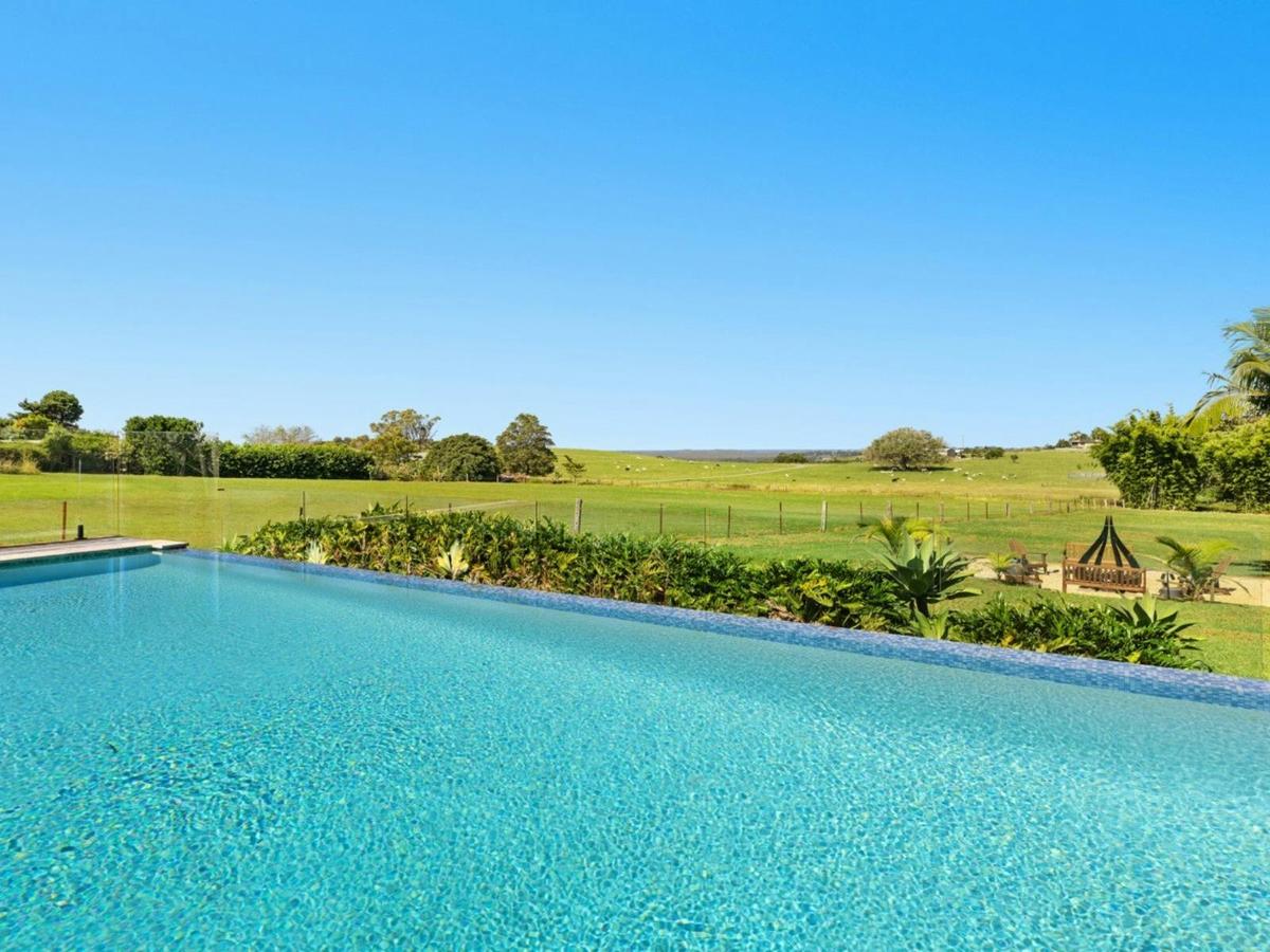 Infinity pool overlooking rolling green farmland.