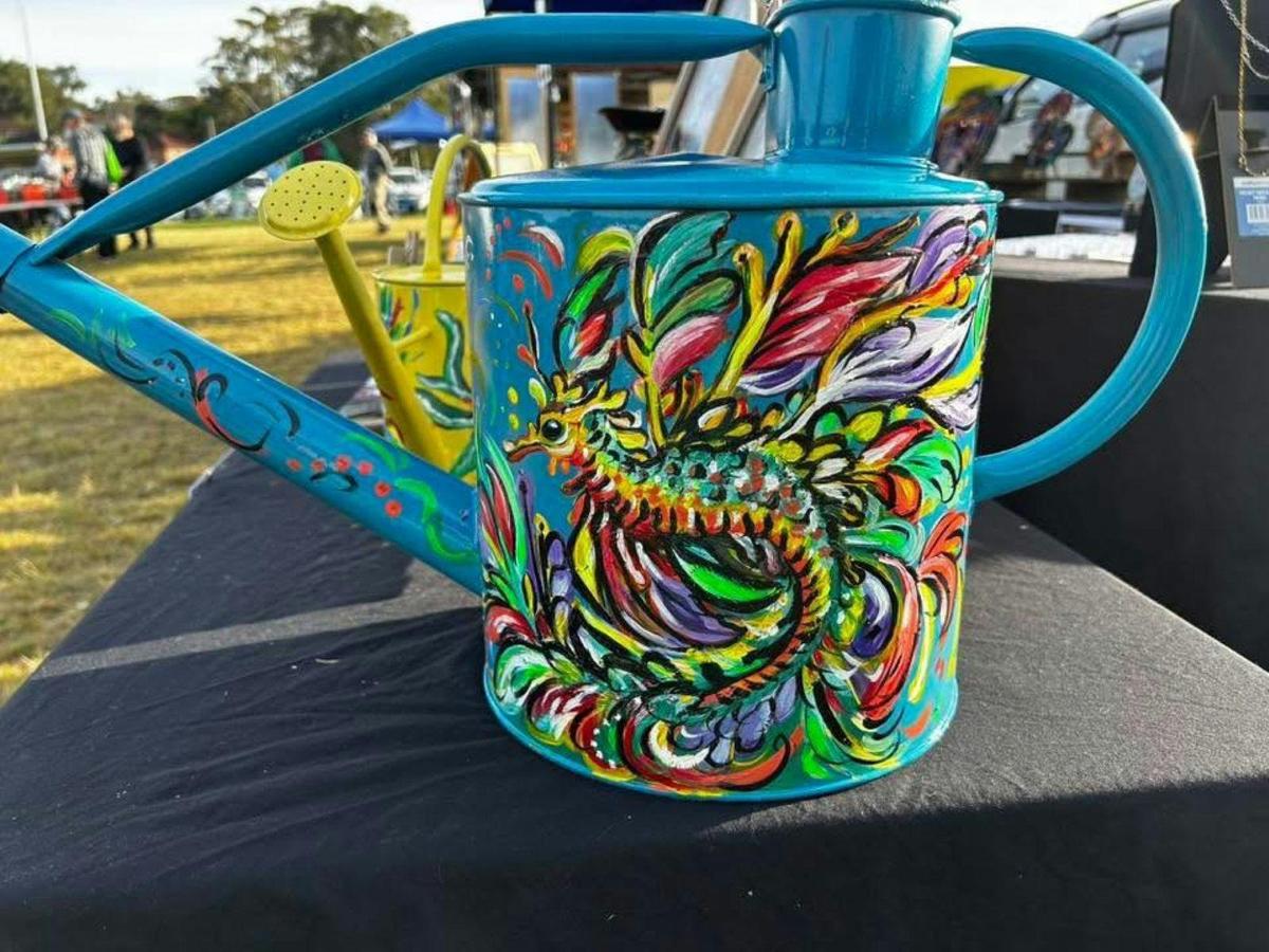Coloured hand painted watering cans at The Nest Market