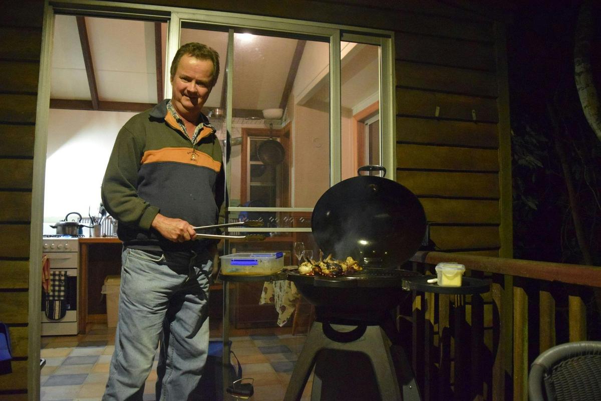BBQing a great meal for tea on cabin veranda
