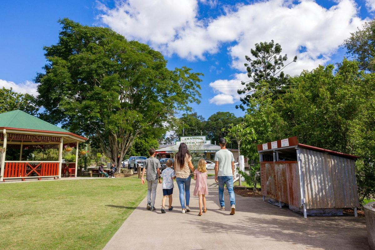 Family walking through the park towards the Amamoor general store